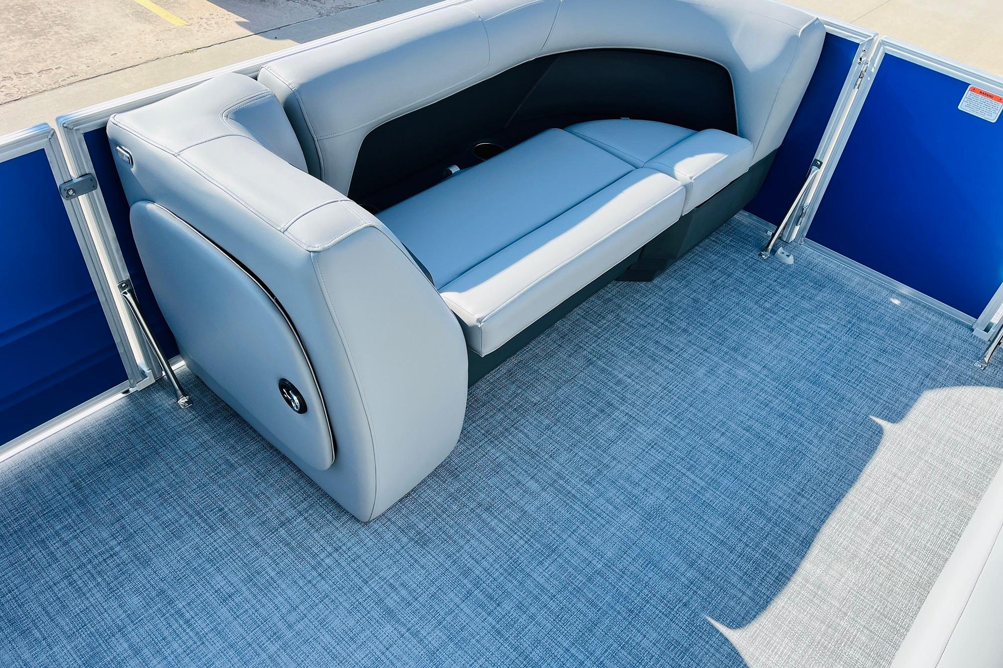 2026 Sun Tracker Party Barge 18 DLX interior with gray seating and blue paneling.