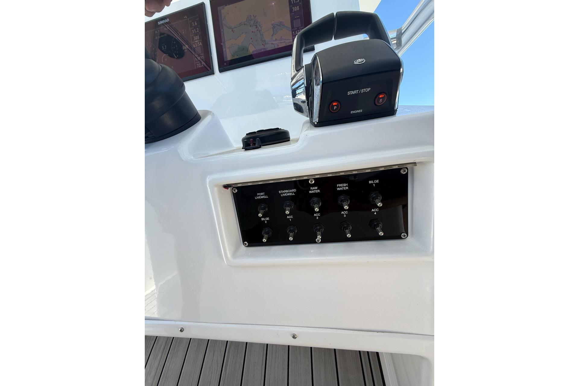 Control panel of 2021 Custom Infusion 34 CC boat with switches and navigation screens.