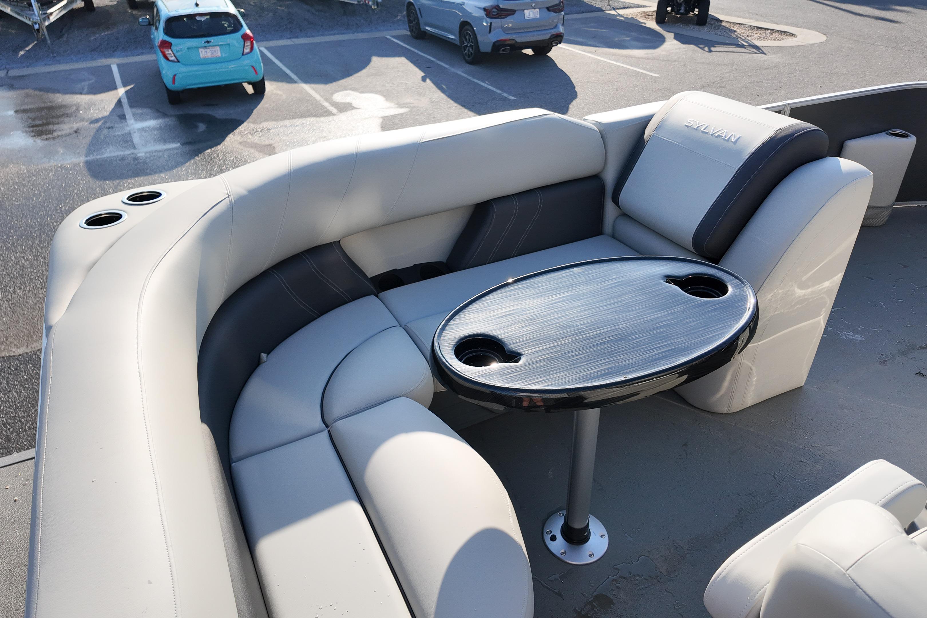 Luxurious seating area on 2026 Sylvan Mirage 818 Fish boat with table and cup holders.