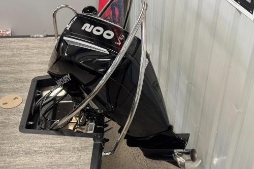 2026 Bennington 22SXSB boat with a powerful Mercury outboard motor displayed indoors.