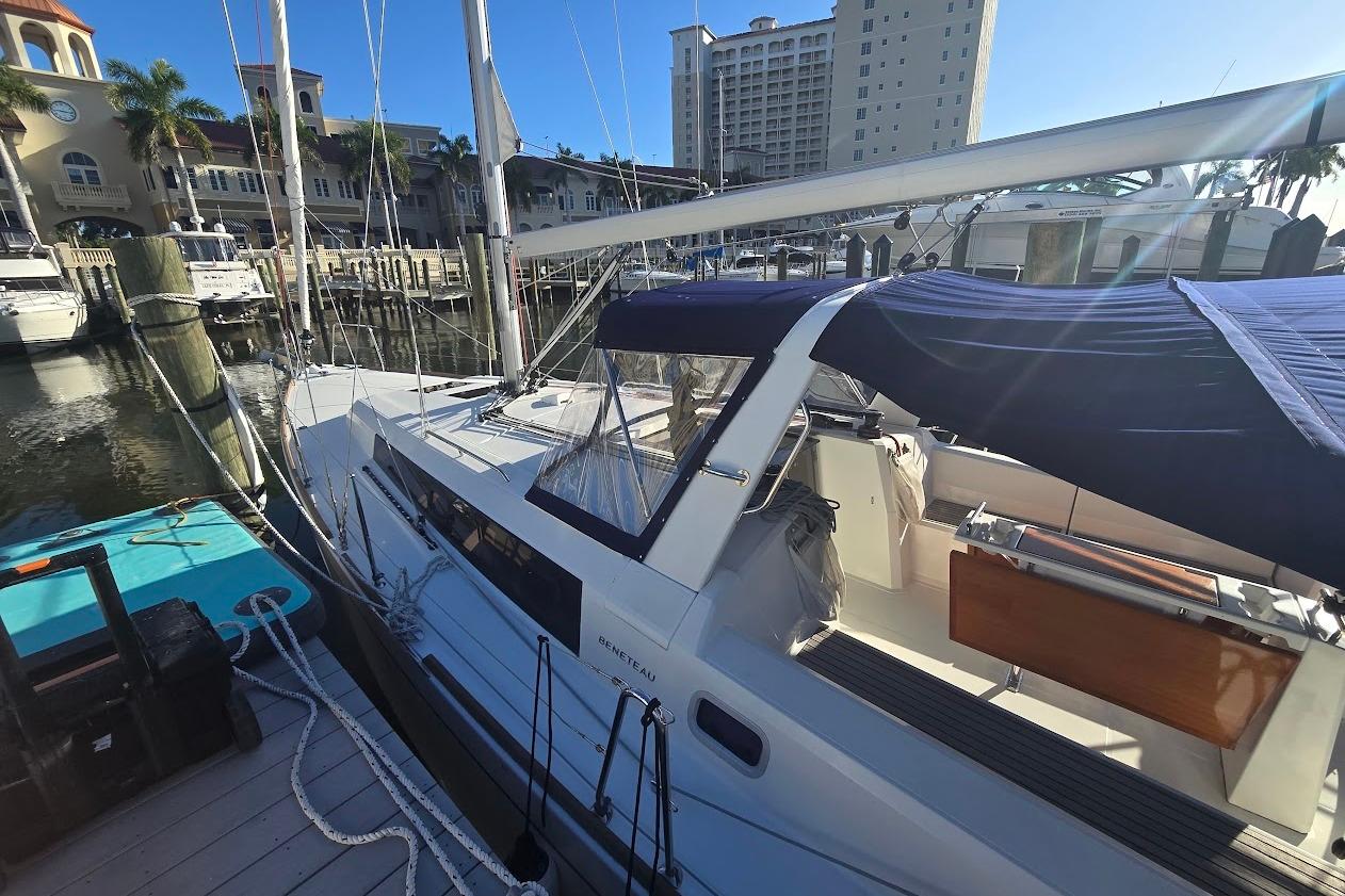 2023 Beneteau Oceanis 38.1 sailboat docked at a marina under clear blue skies.
