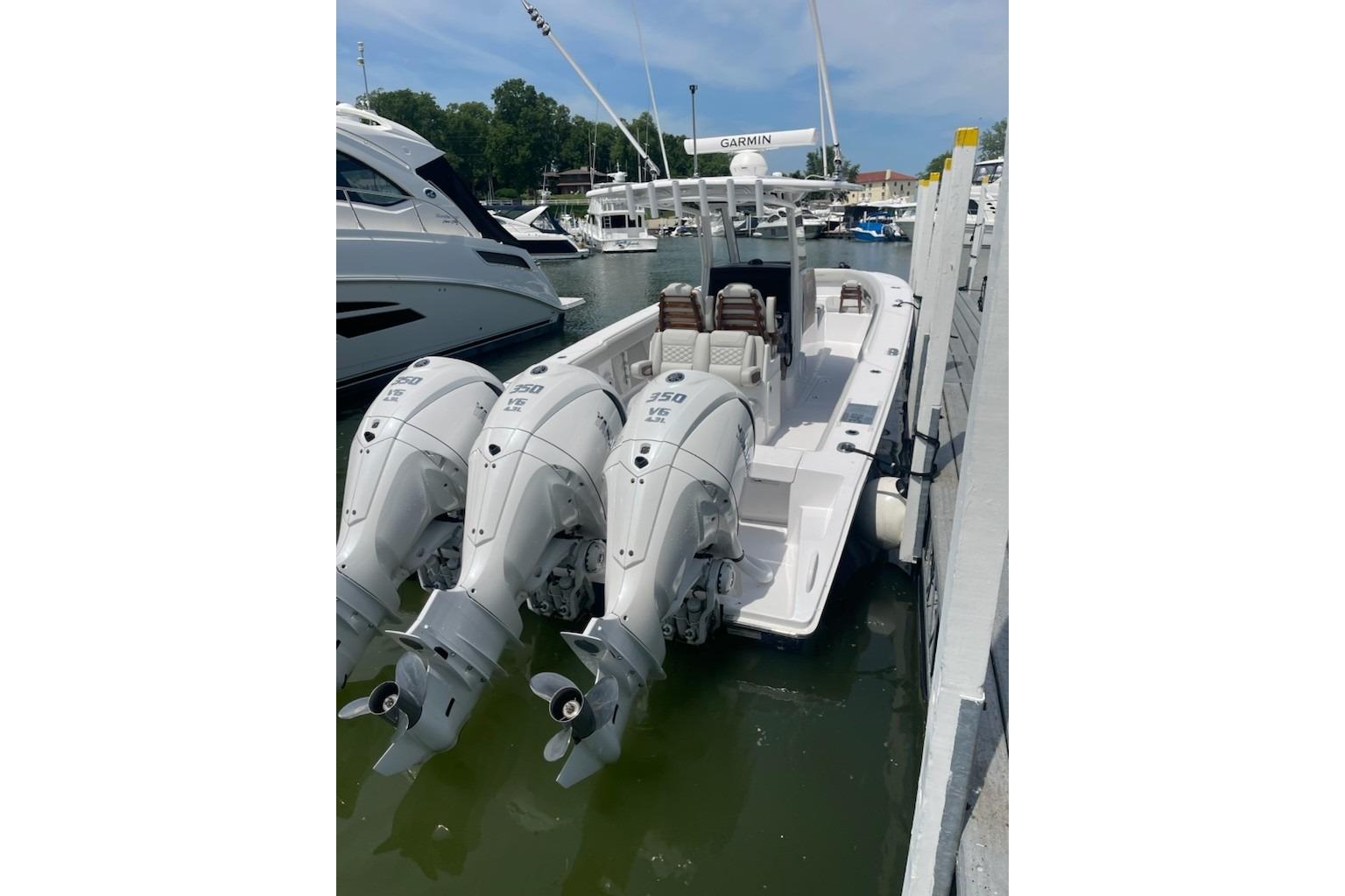 2026 Jupiter 340LS boat with triple outboard engines docked at marina.