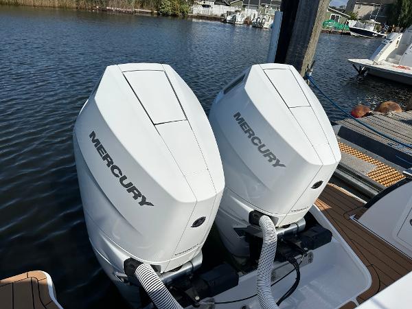 Twin Mercury outboard engines on a 2025 Southport 33 FE boat docked by the water.