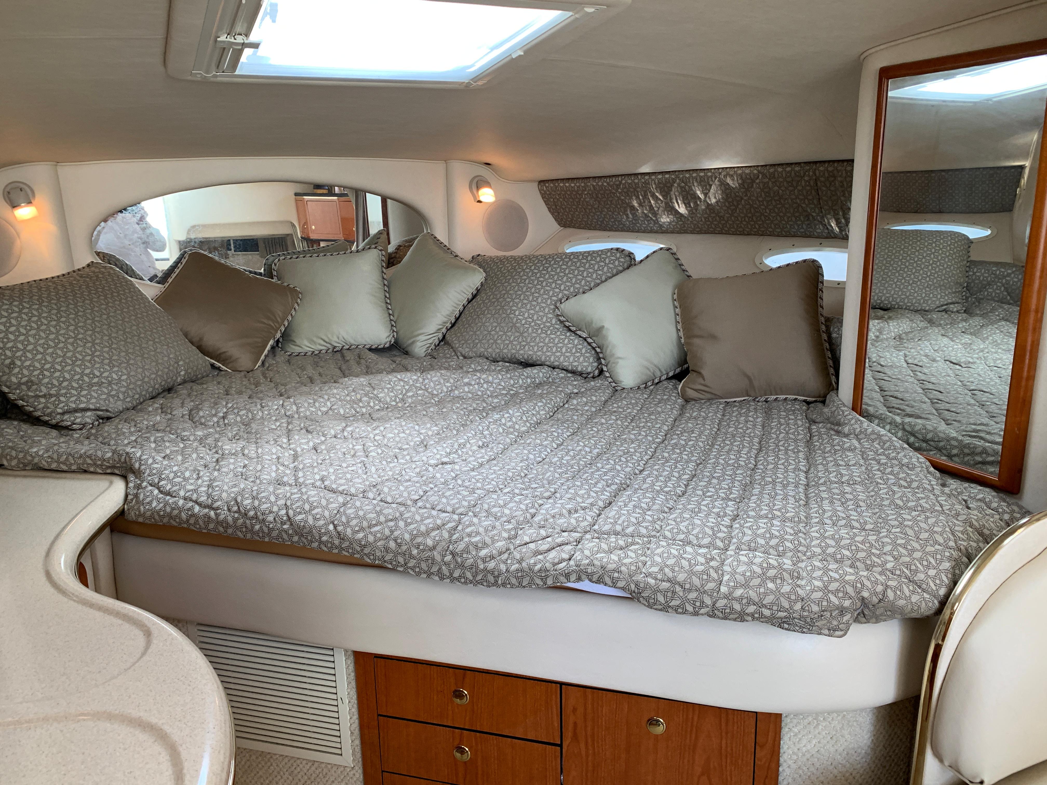 Luxurious cabin interior of 2001 Sea Ray 310 Sundancer yacht with cozy bedding.