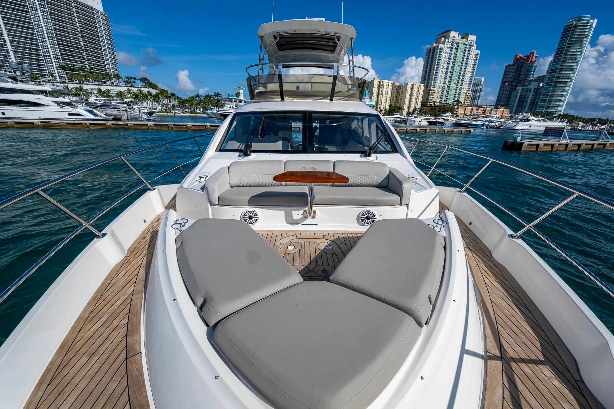 2018 Sea Ray L550 Fly yacht with luxurious deck, docked in a vibrant marina.