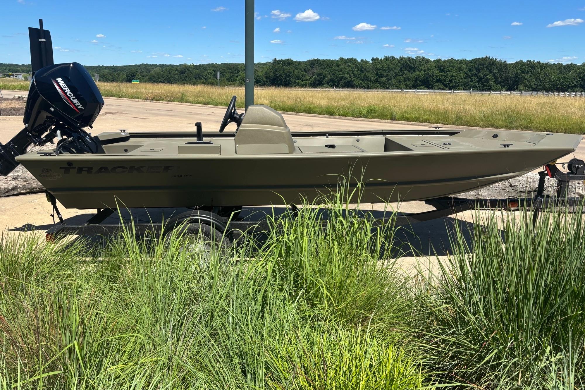2025 Tracker Grizzly 1648 SC boat on trailer, parked outdoors with grassy background.