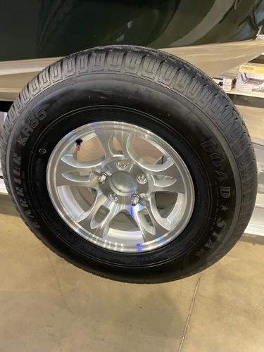 2025 Mako 18 Pro Skiff Backwater Edition trailer tire with alloy wheel on display.