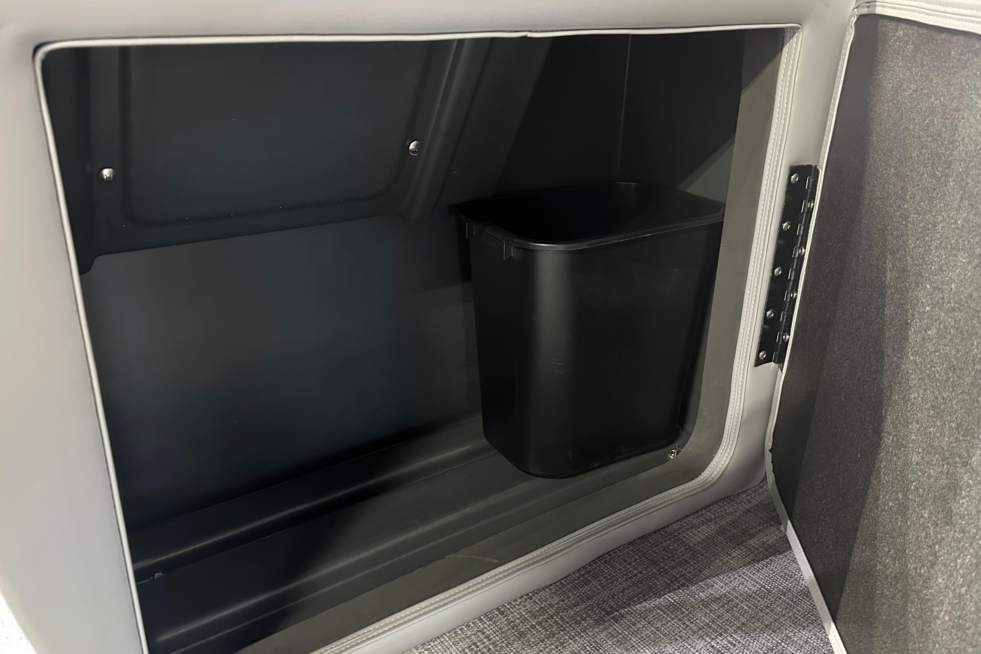 Interior storage compartment with a black bin in a 2026 Sun Tracker SportFish 22 DLX boat.