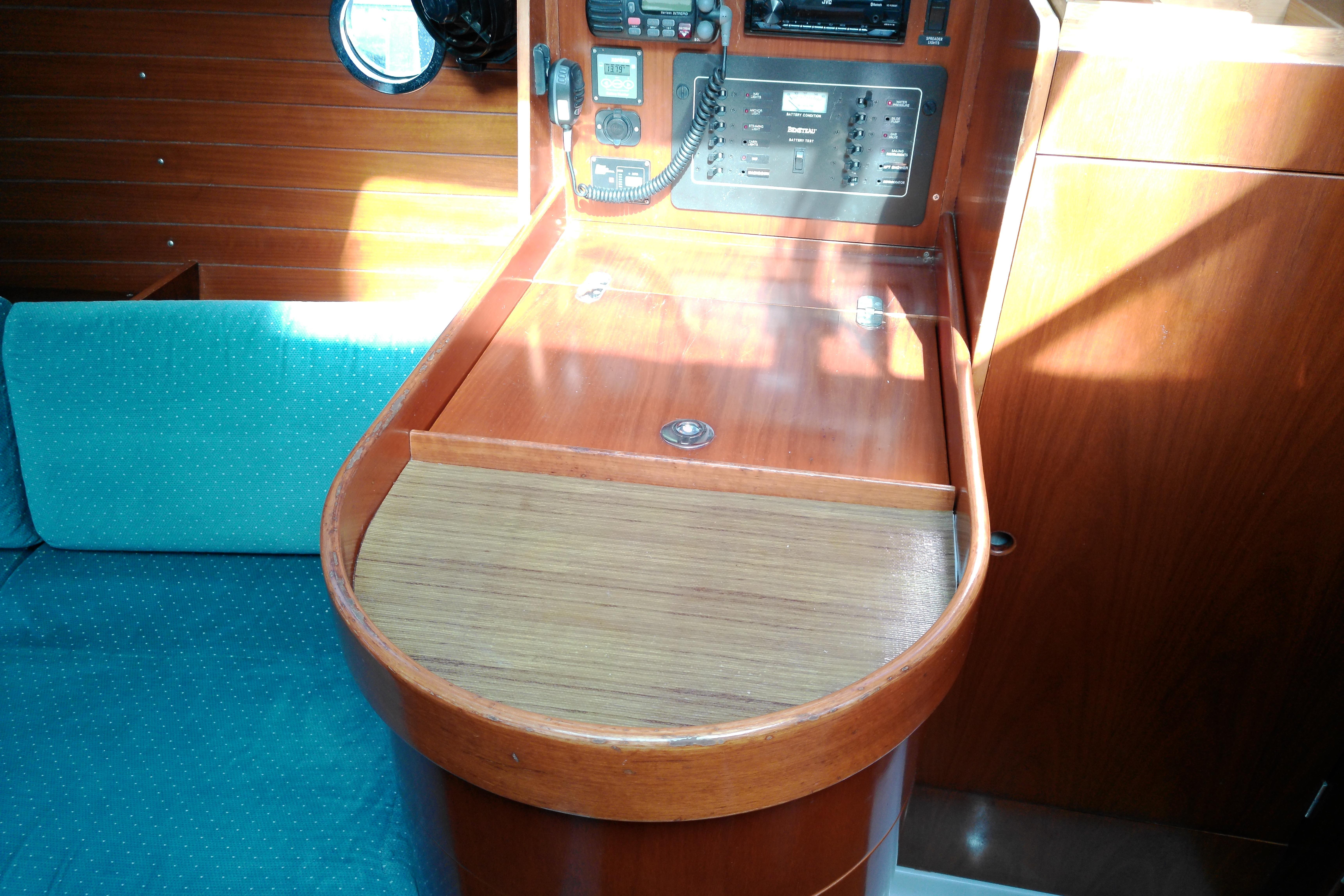 Interior of 1993 Beneteau First 310 sailboat with navigation station and teal seating.
