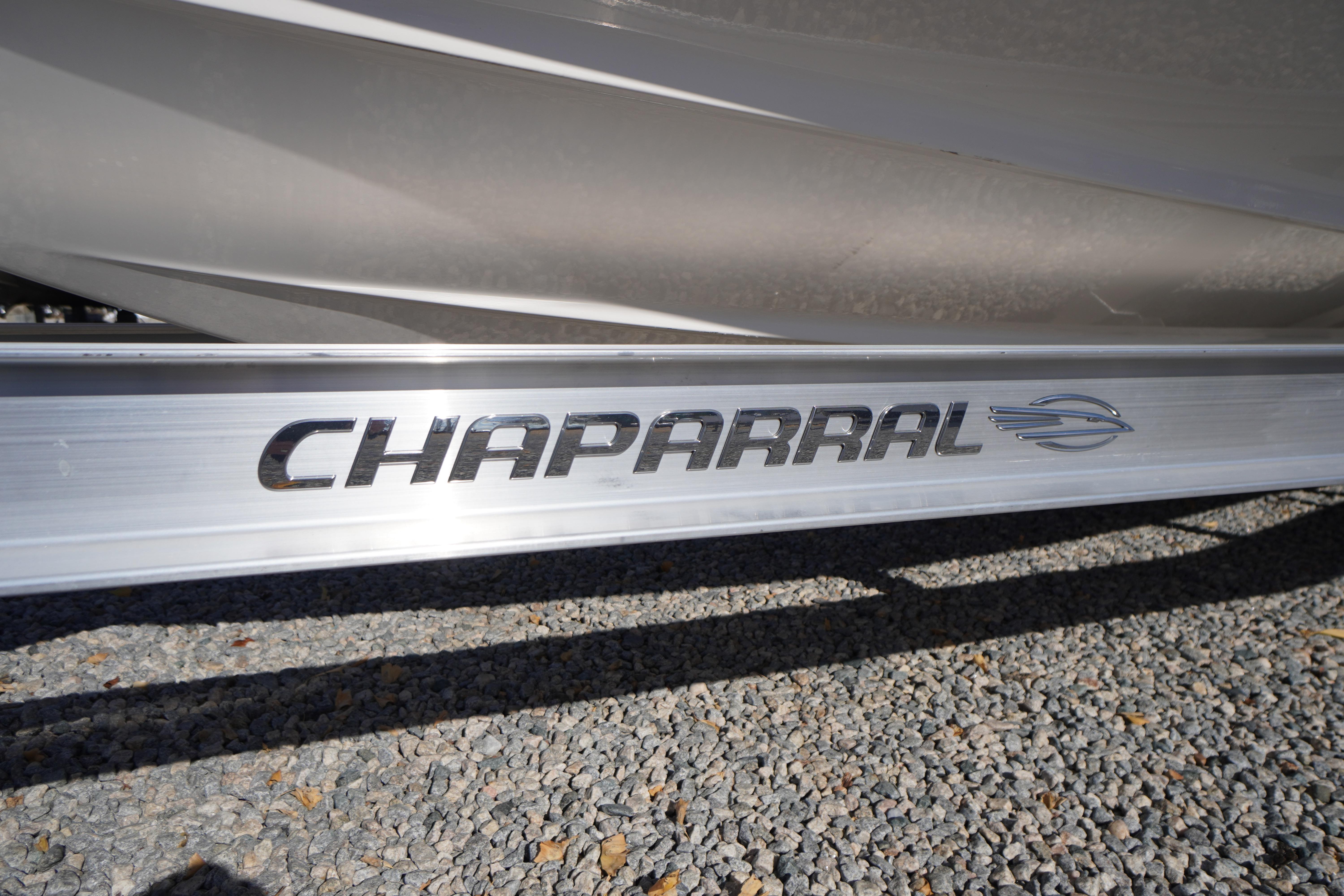 2026 Chaparral 23 SSi OB boat logo on metallic surface, gravel background.