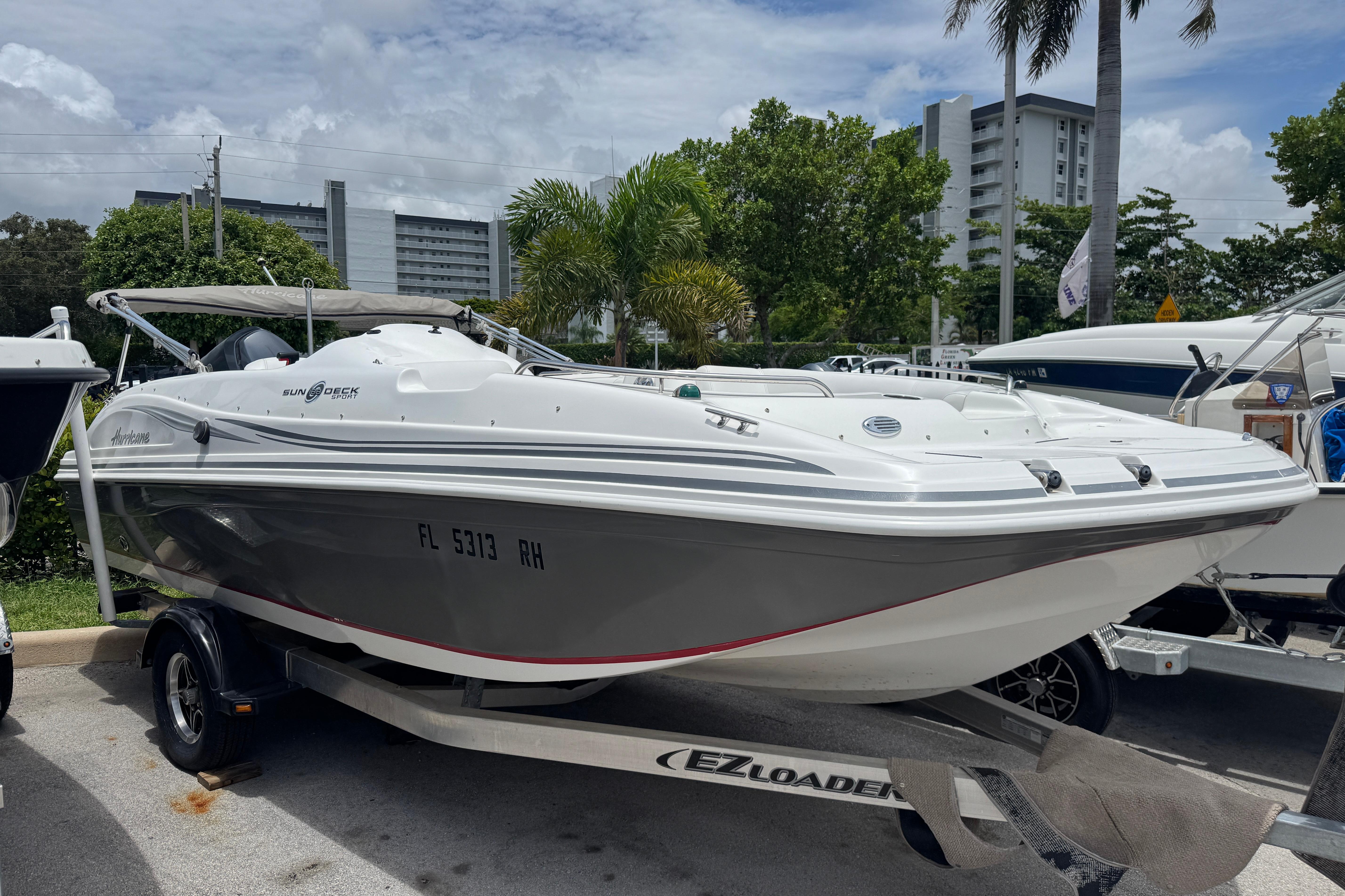 2013 Hurricane SunDeck Sport 188 OB boat on trailer, parked outdoors.