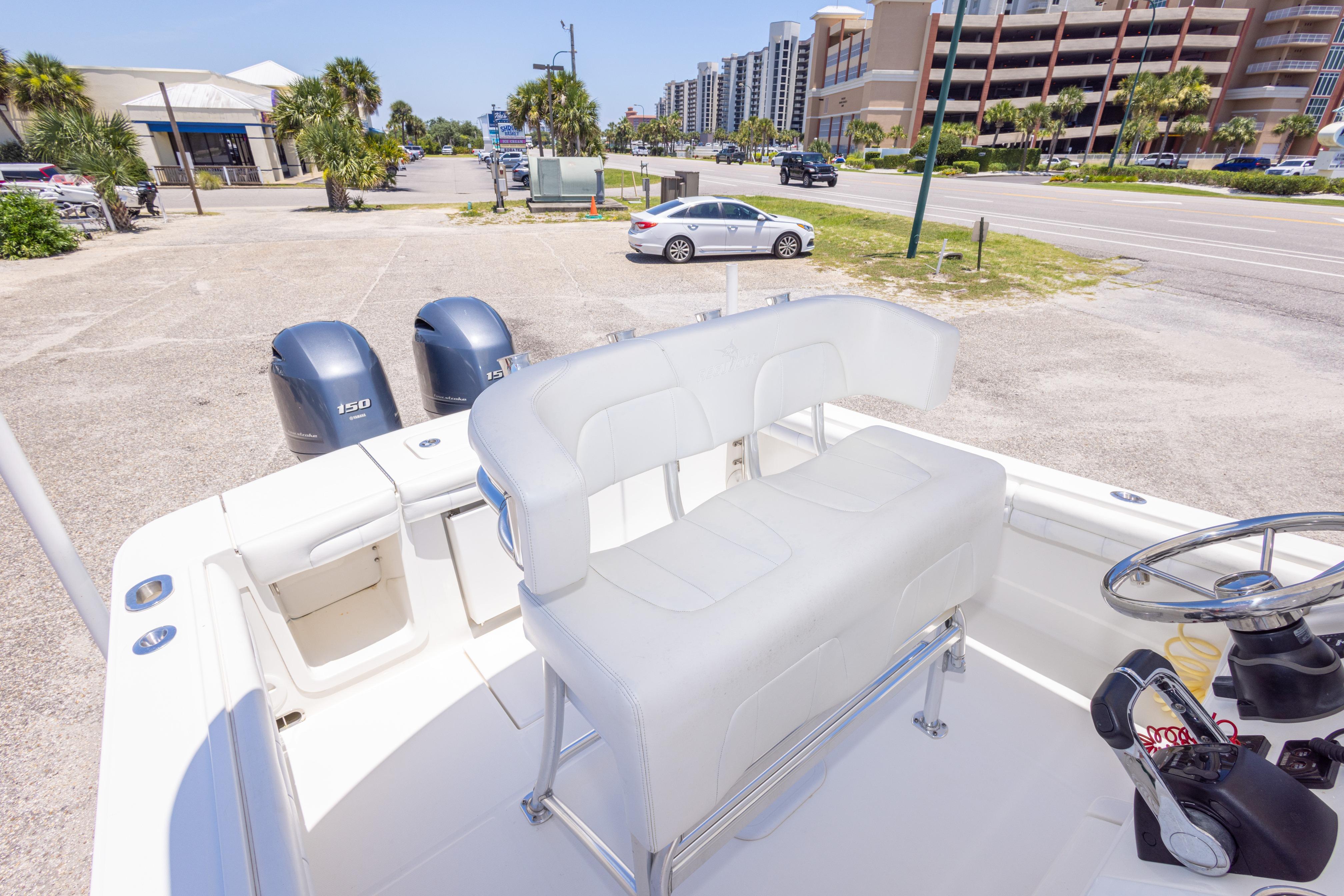 2019 Regulator 23 Center Console boat with dual engines, parked near a coastal road.