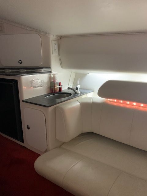 Interior of a 2001 Fountain Lightning with white seating and sink.
