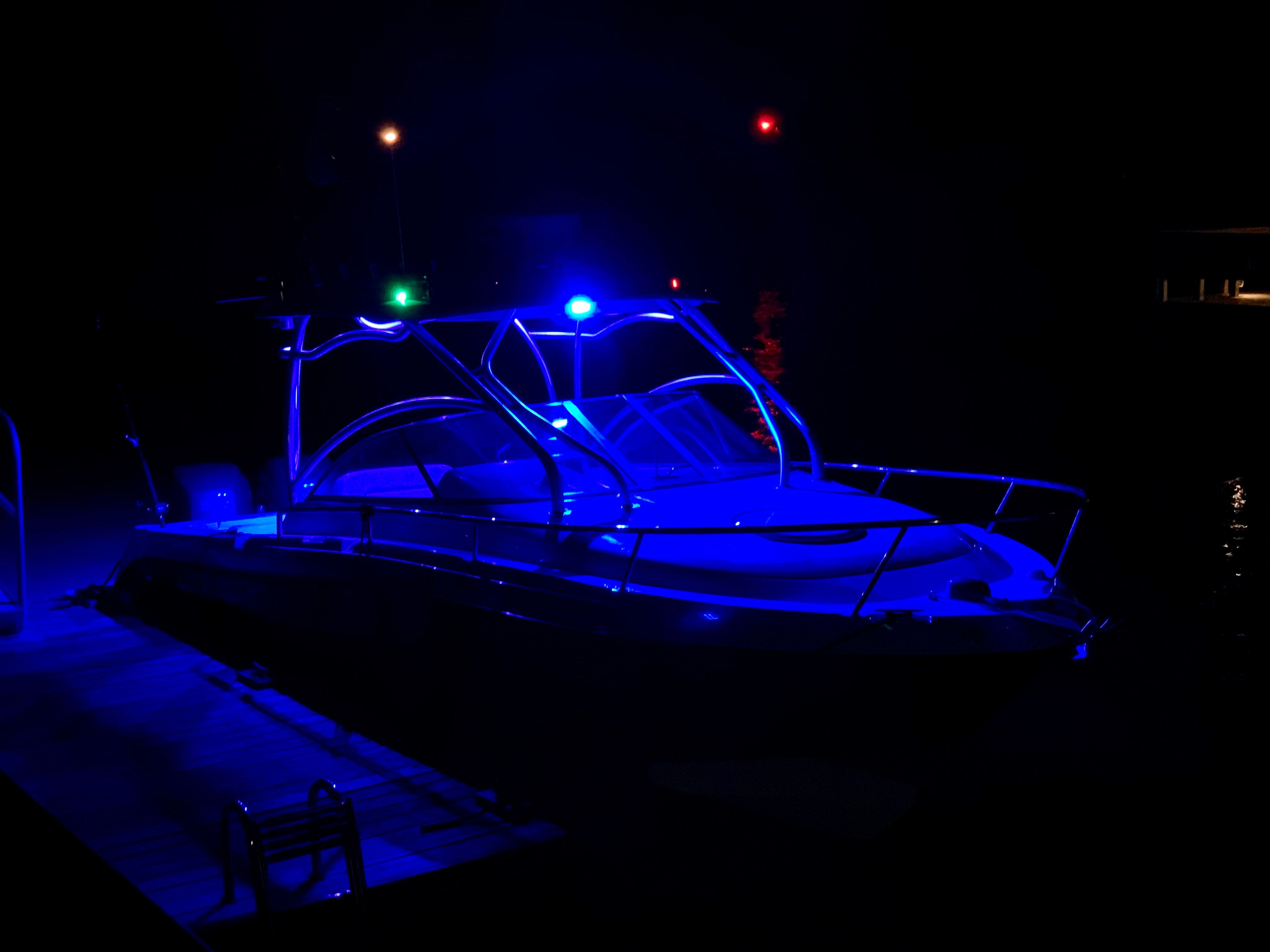 A 2023 Hydra-Sports Vector-VX boat illuminated by blue lights, docked at night.