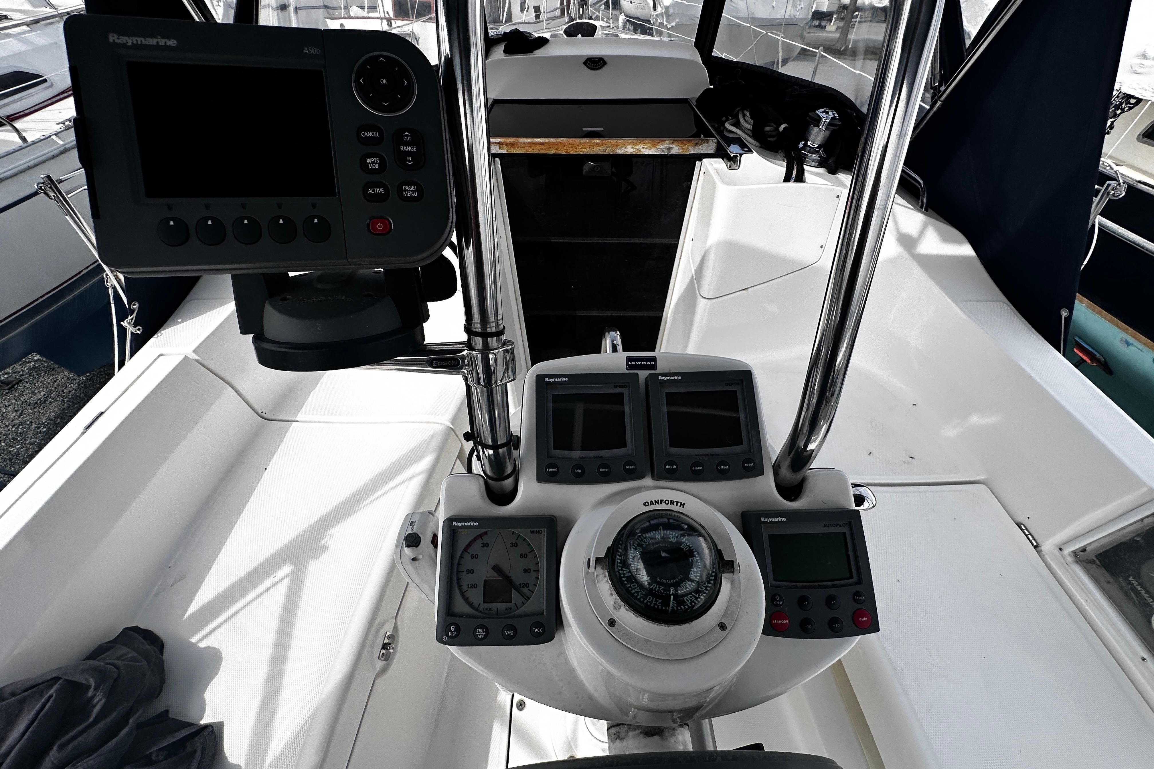 Cockpit of 2004 Hunter 33 sailboat with navigation instruments and steering wheel.