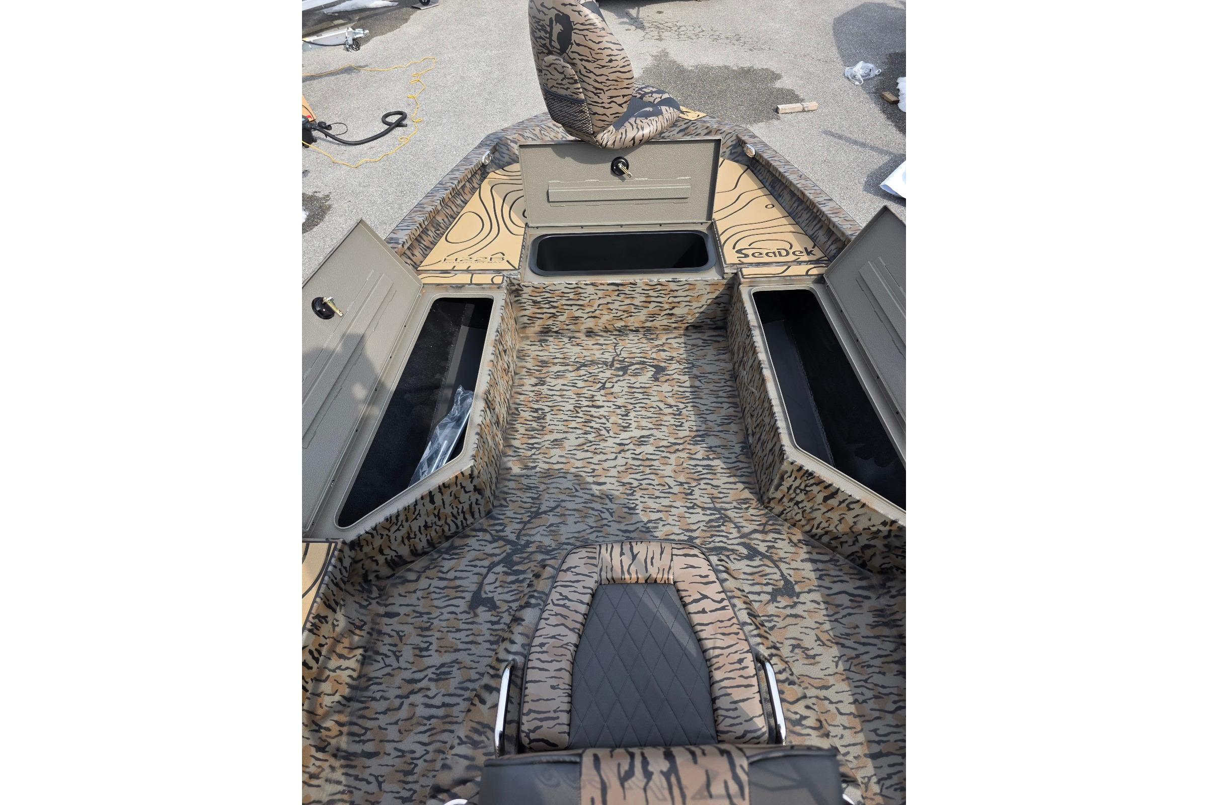 2026 Xpress H22B Bay boat interior with camo design and storage compartments.