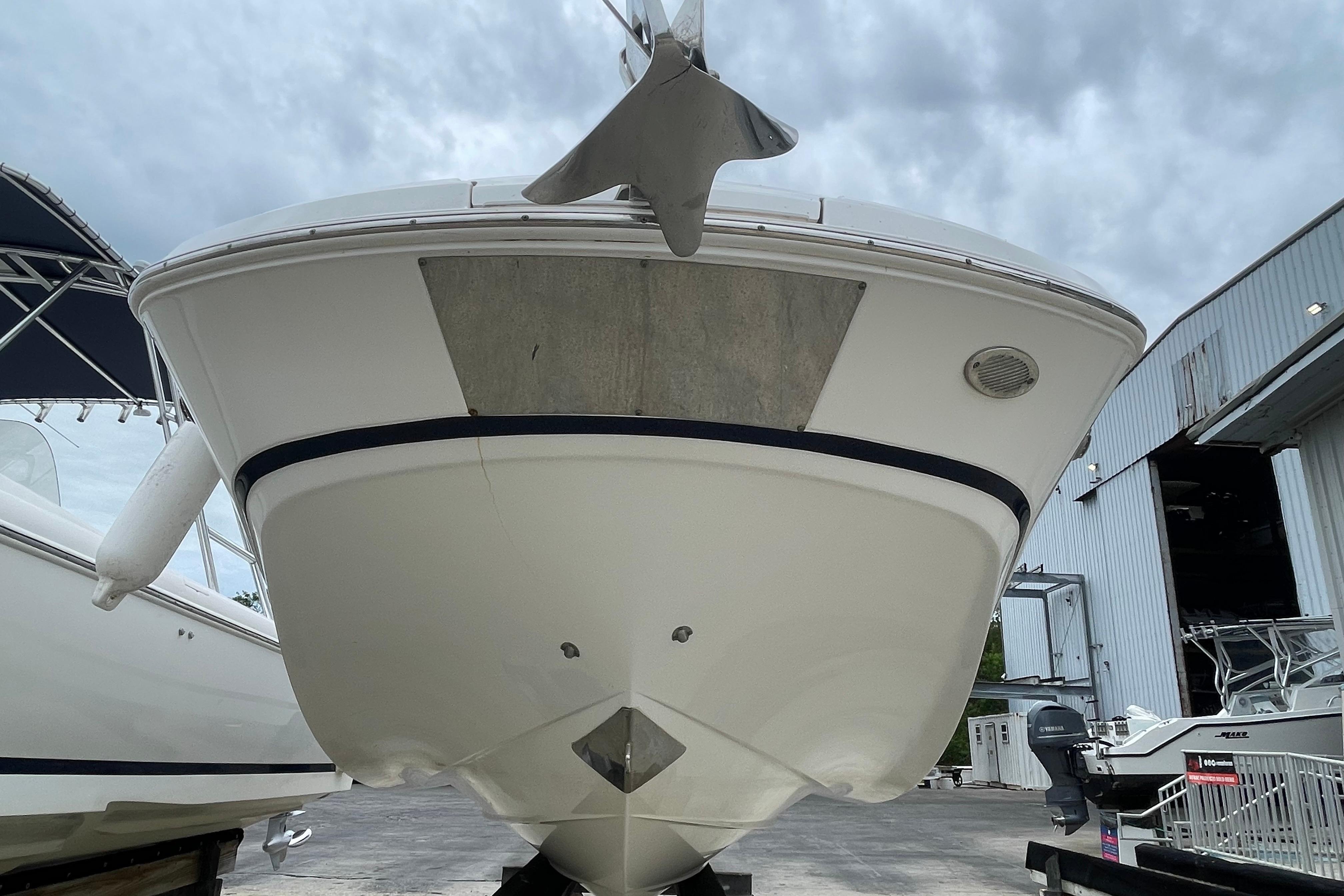 2022 Four Winns HD8 OB boat, front view, docked at a marina under cloudy skies.