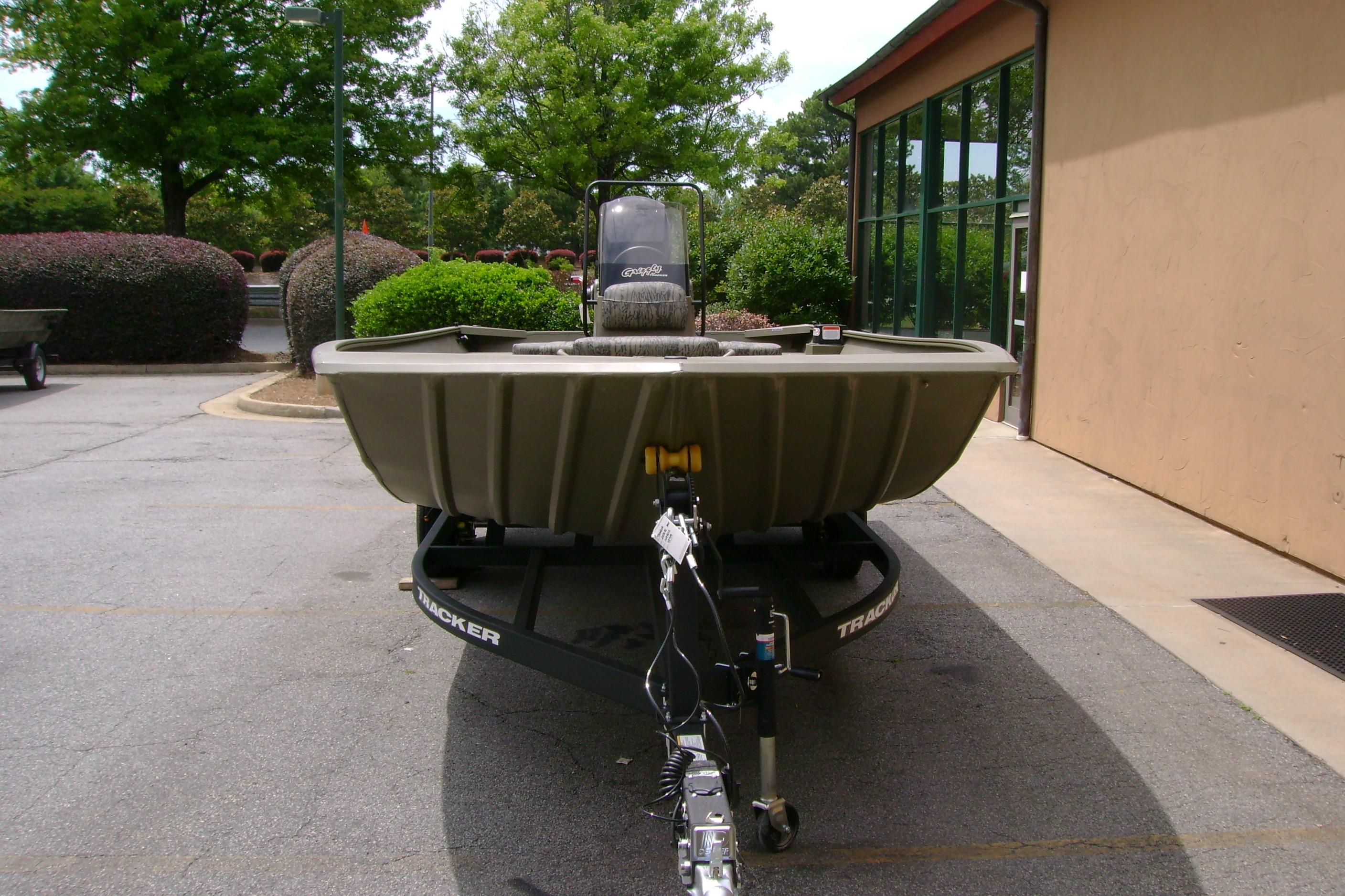 2026 Tracker Grizzly 2072 CC boat on trailer, parked outdoors near a building.