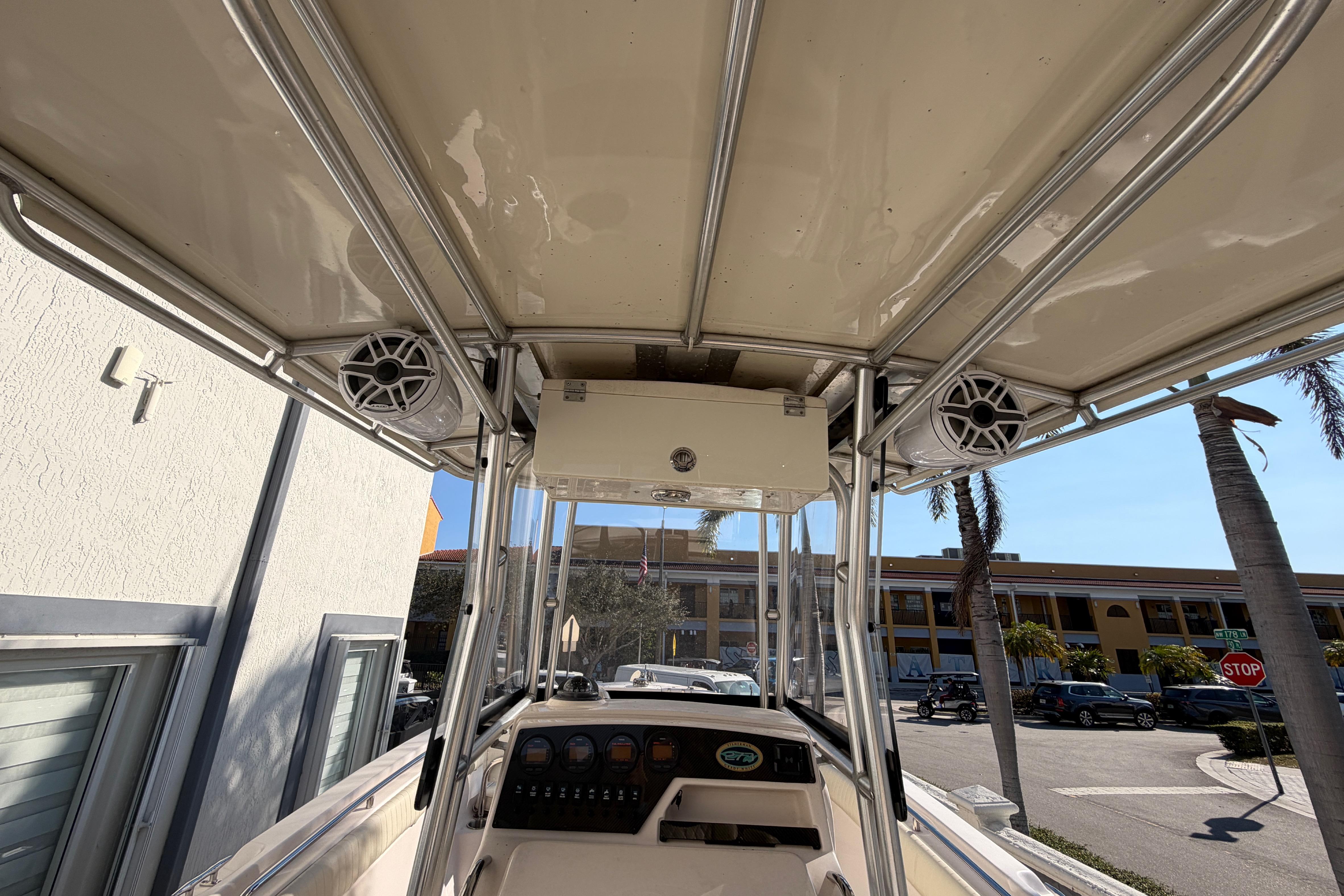 2004 Grady White 273 boat interior with speakers and control panel, docked near palm trees.