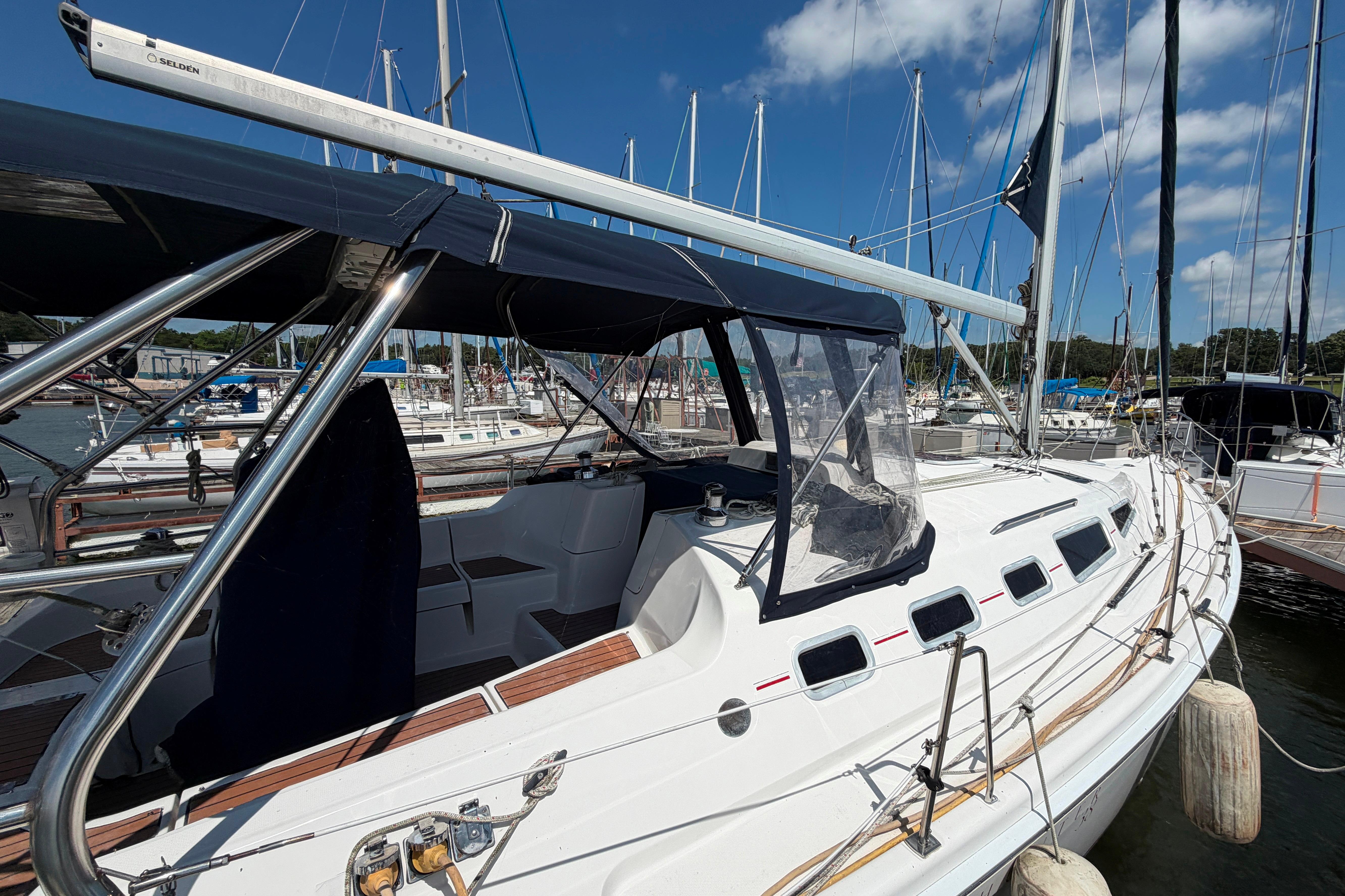 2005 Hunter 38 sailboat docked at marina under clear blue sky.