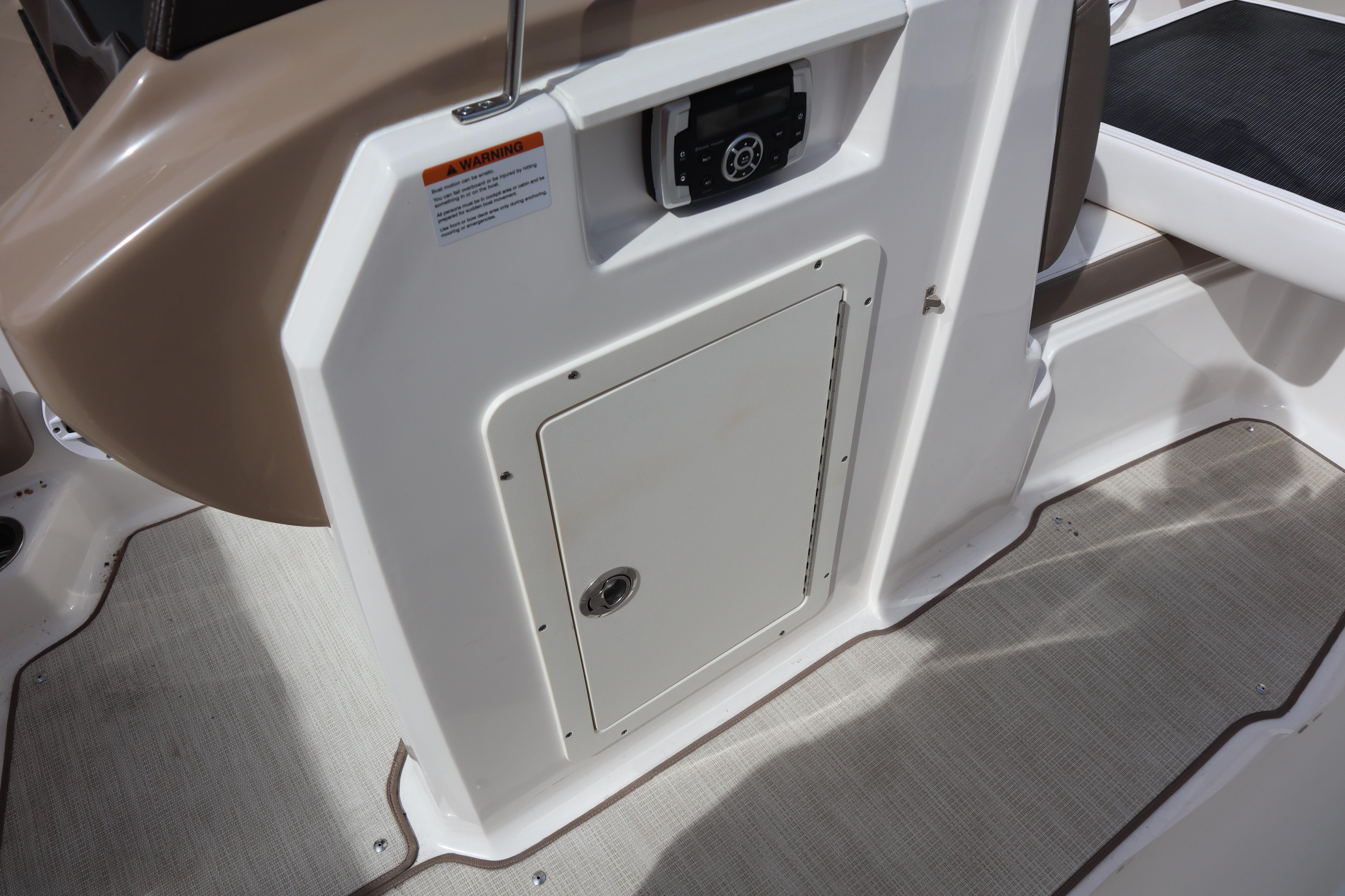 2021 Chaparral 21 SSi boat interior with storage compartment and control panel.