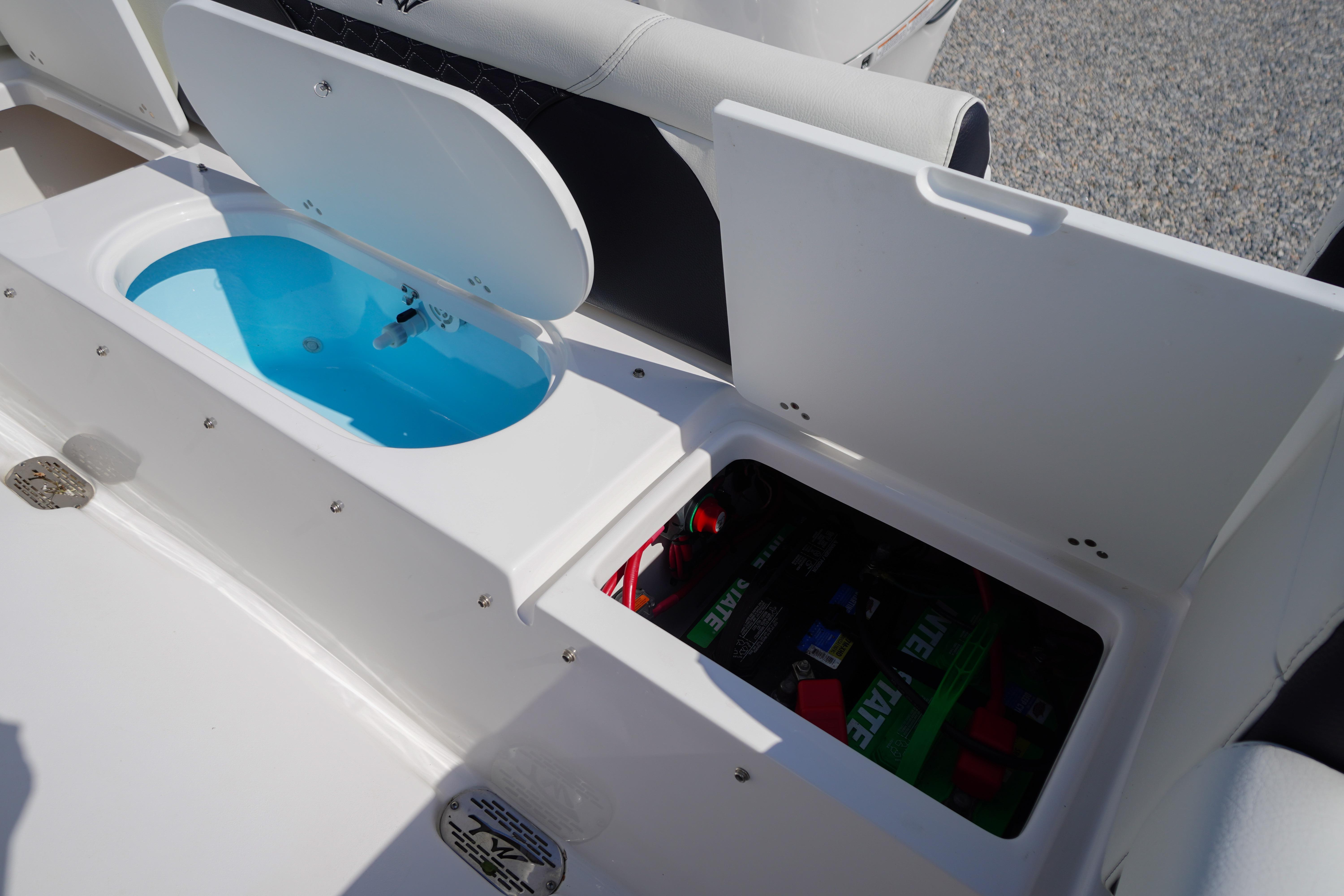 2025 Tidewater 232 SS boat storage compartments with open lids, showcasing interior features.