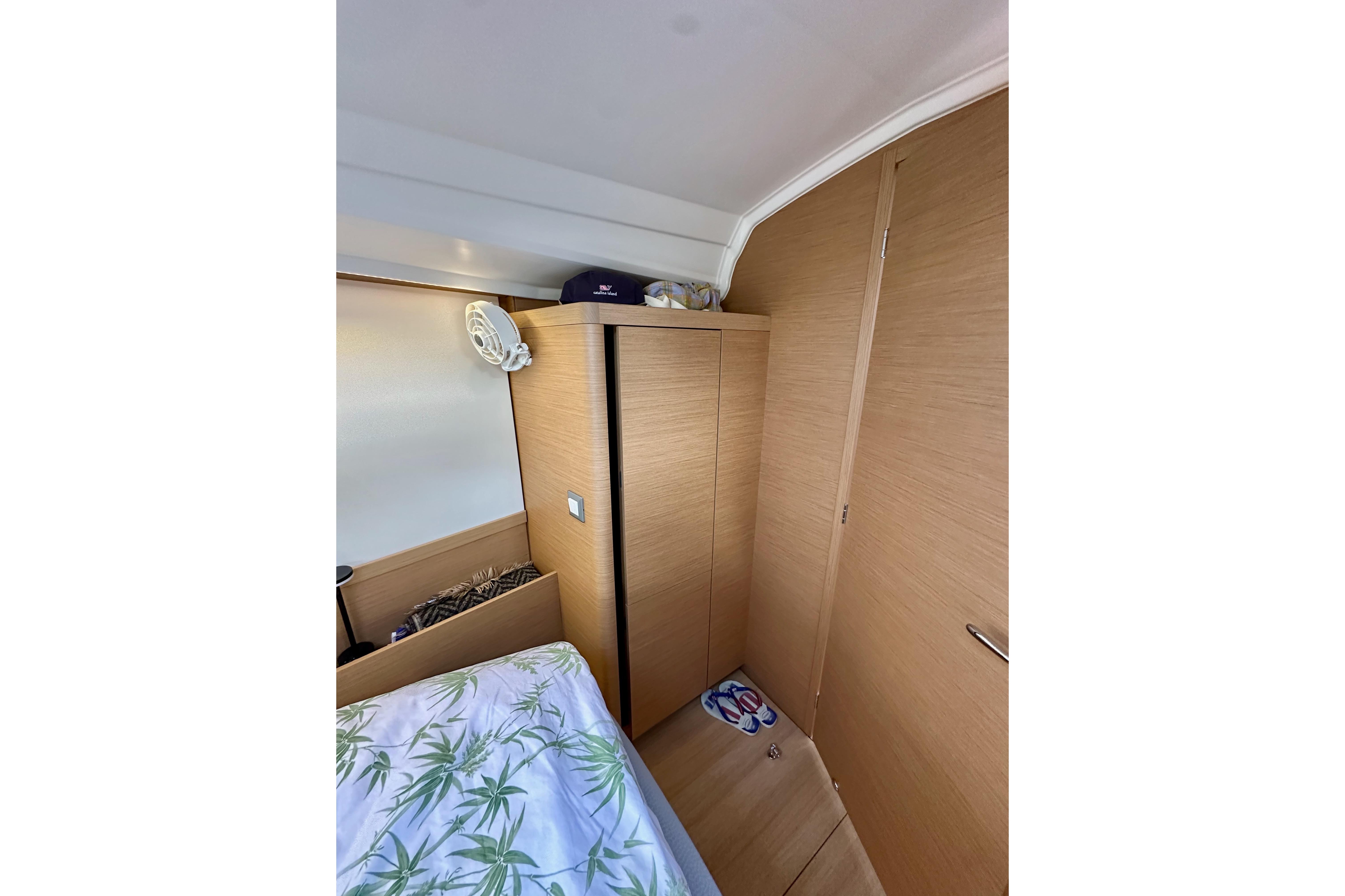 2024 Jeanneau Sun Odyssey 410 cabin interior with wooden cabinetry and bed.
