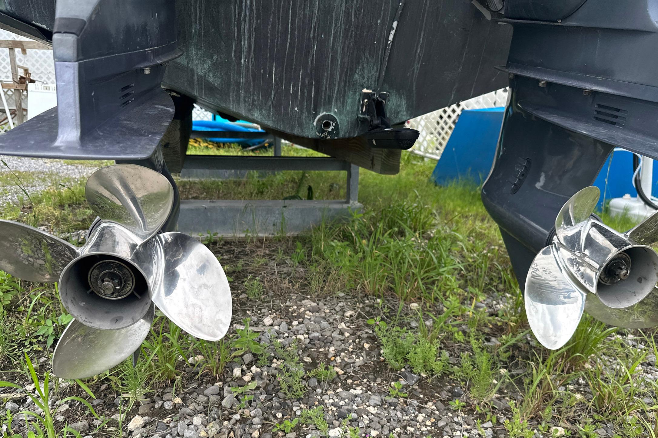 2006 Grady-White Marlin 300 boat propellers on grassy ground.