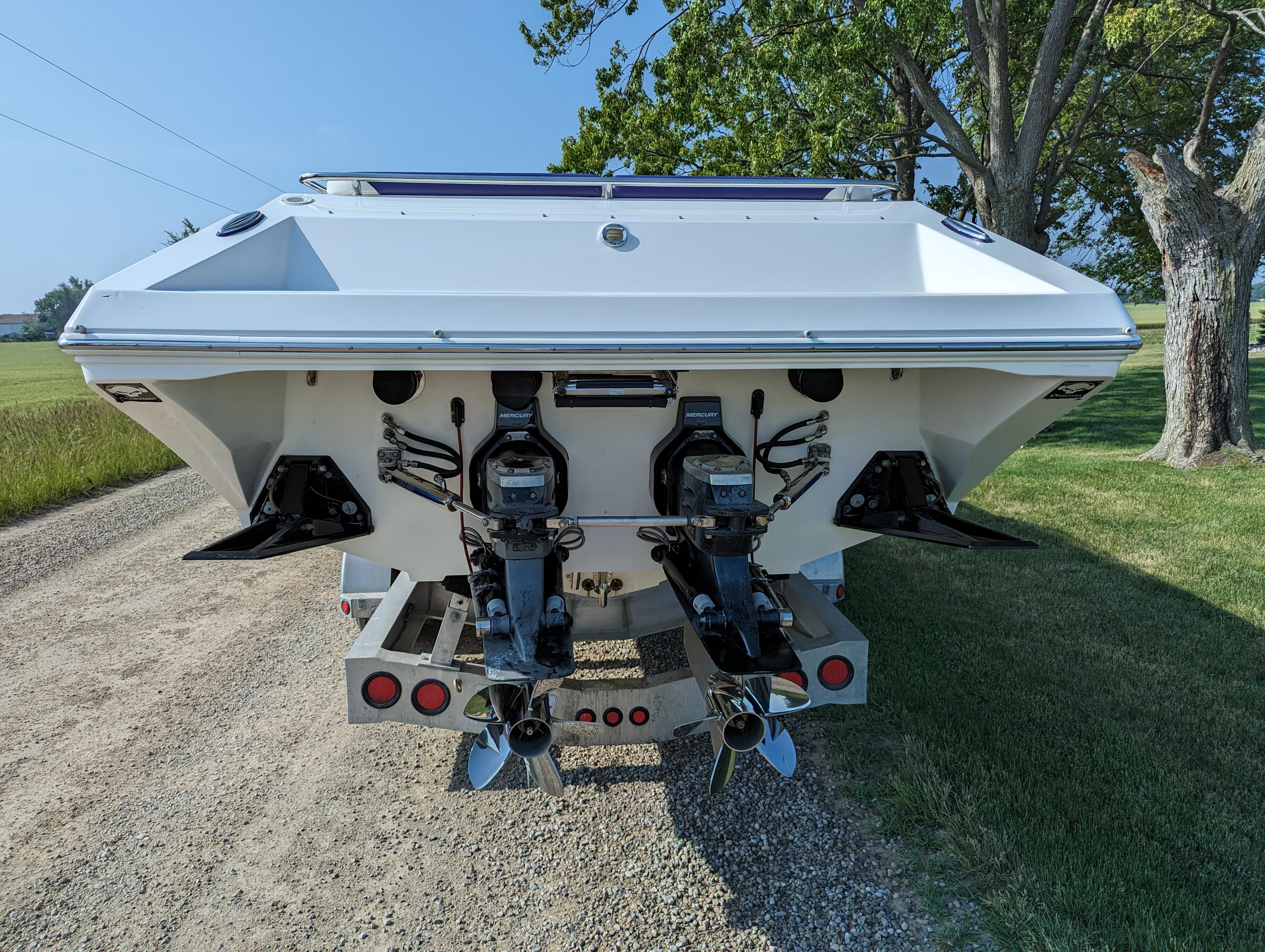Rear view of a 2006 Fountain 42 boat on a trailer, showcasing dual outboard motors.