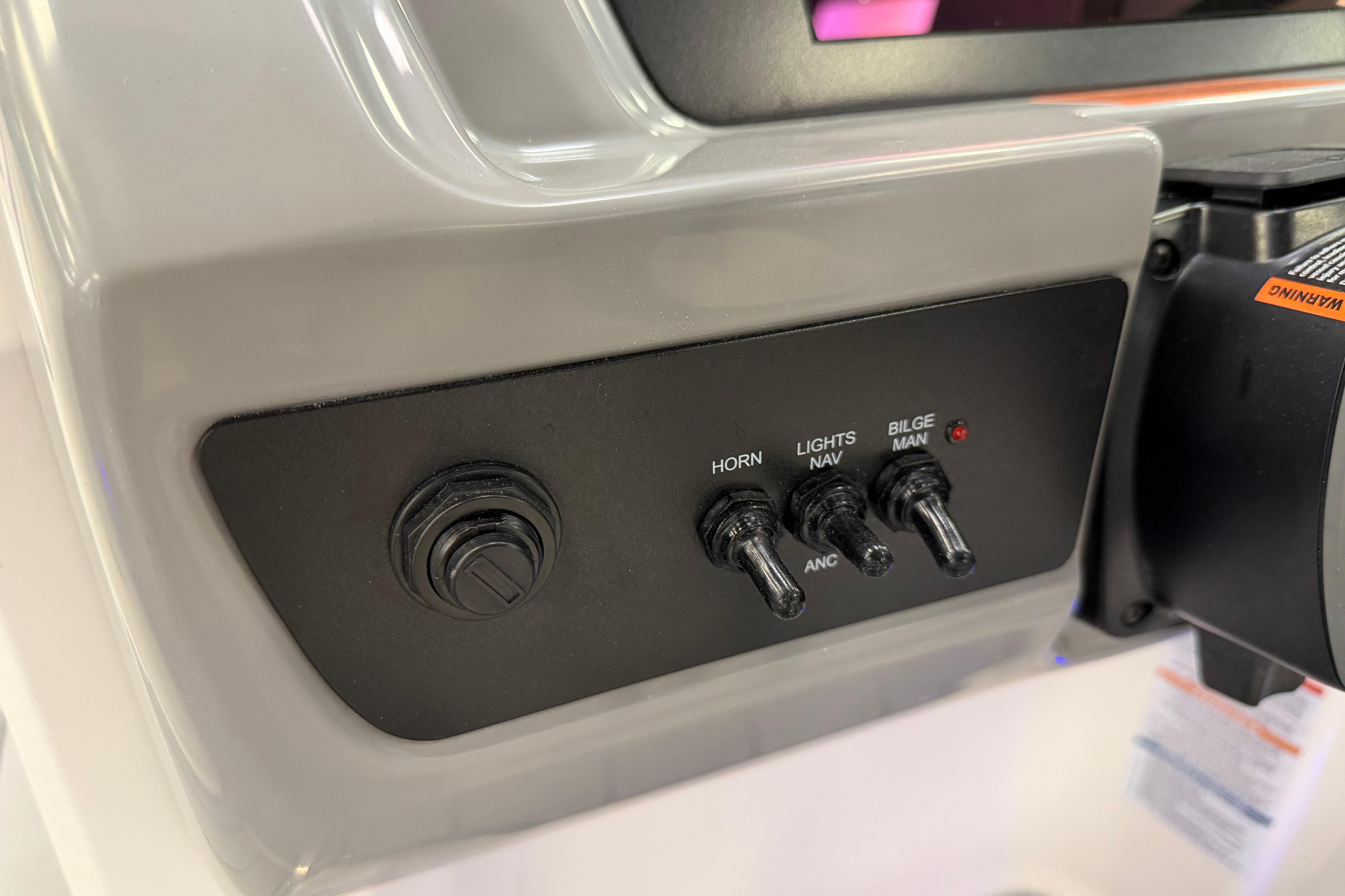 Control panel of 2025 Chaparral 21 SSi OB boat with switches for horn, lights, and bilge.