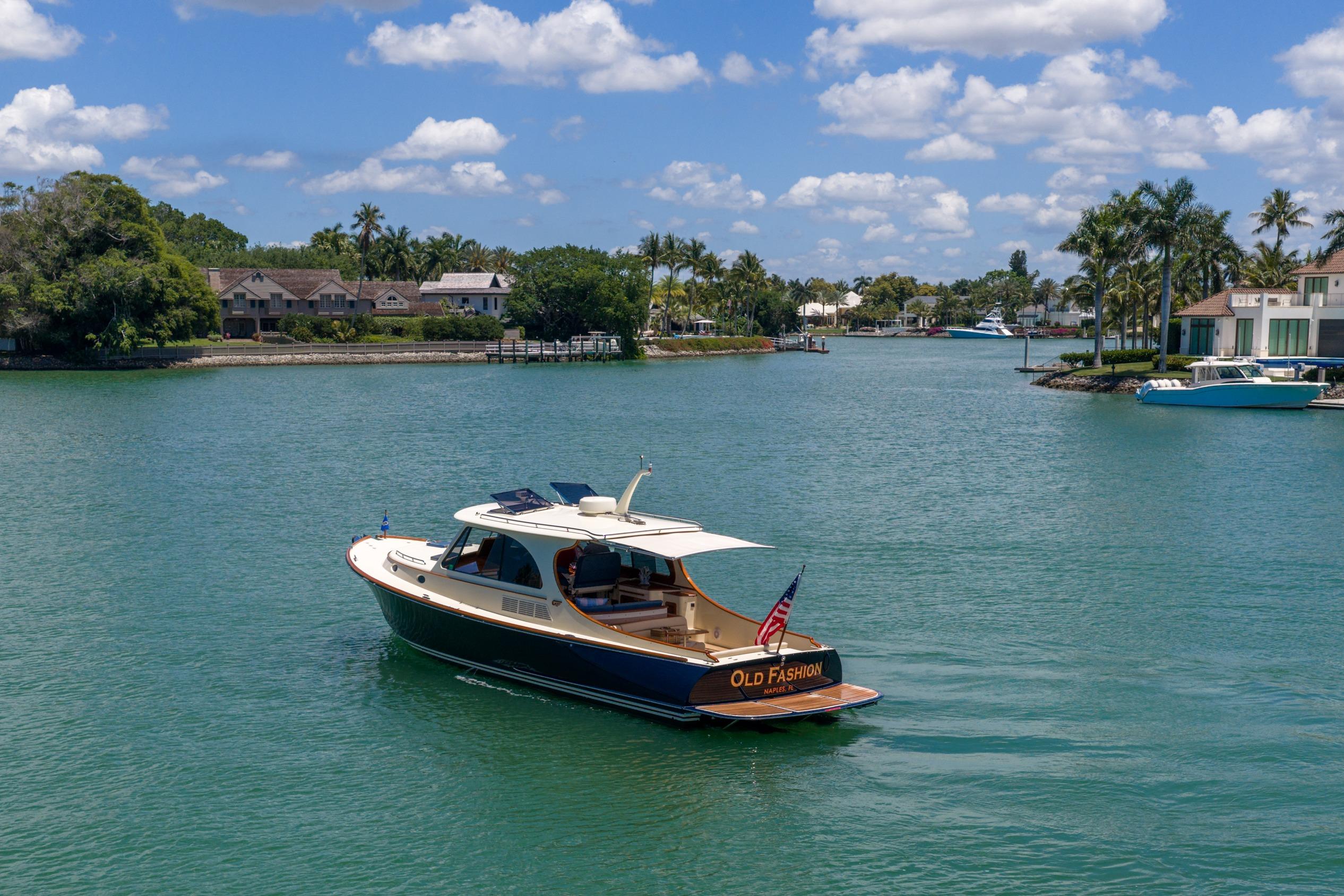 Hinckley Picnic Boat 40 (2020) cruising on a scenic waterway with lush surroundings.