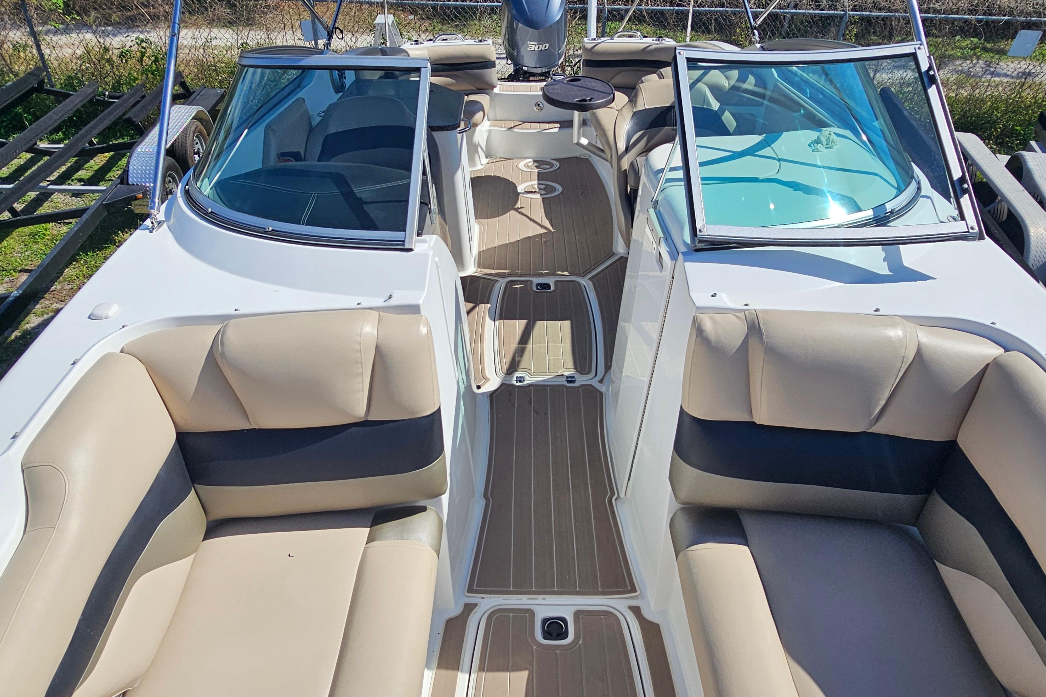 2016 Hurricane SunDeck 2690 OB boat interior with beige seating and dual windshields.
