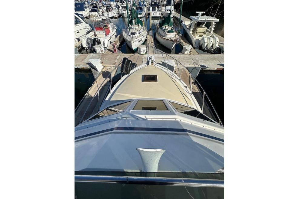 1985 Egg Harbor 33 Sedan yacht docked at a marina, surrounded by other boats.