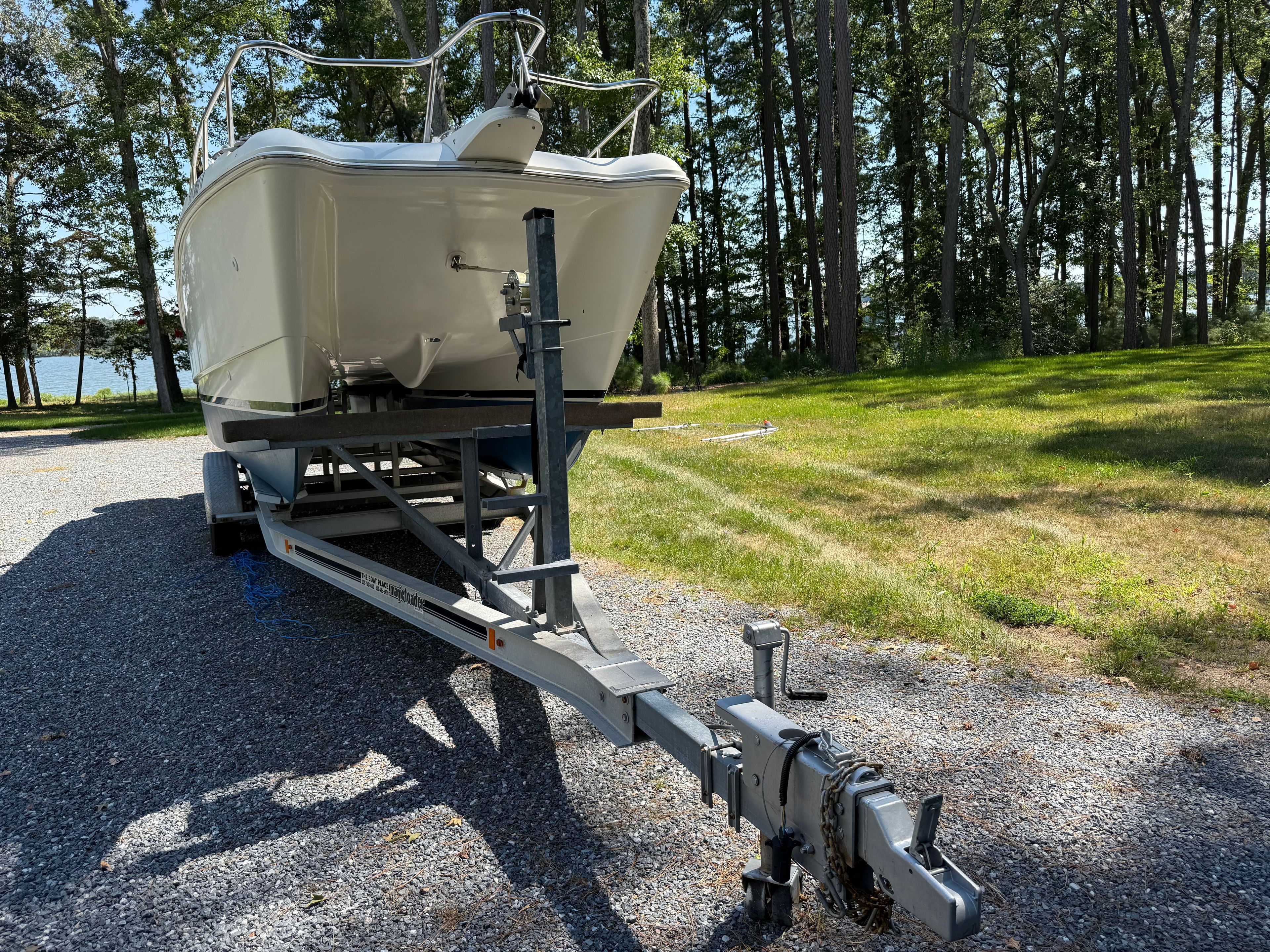 World Cat 246 DC boat on trailer in wooded area, year 2002.