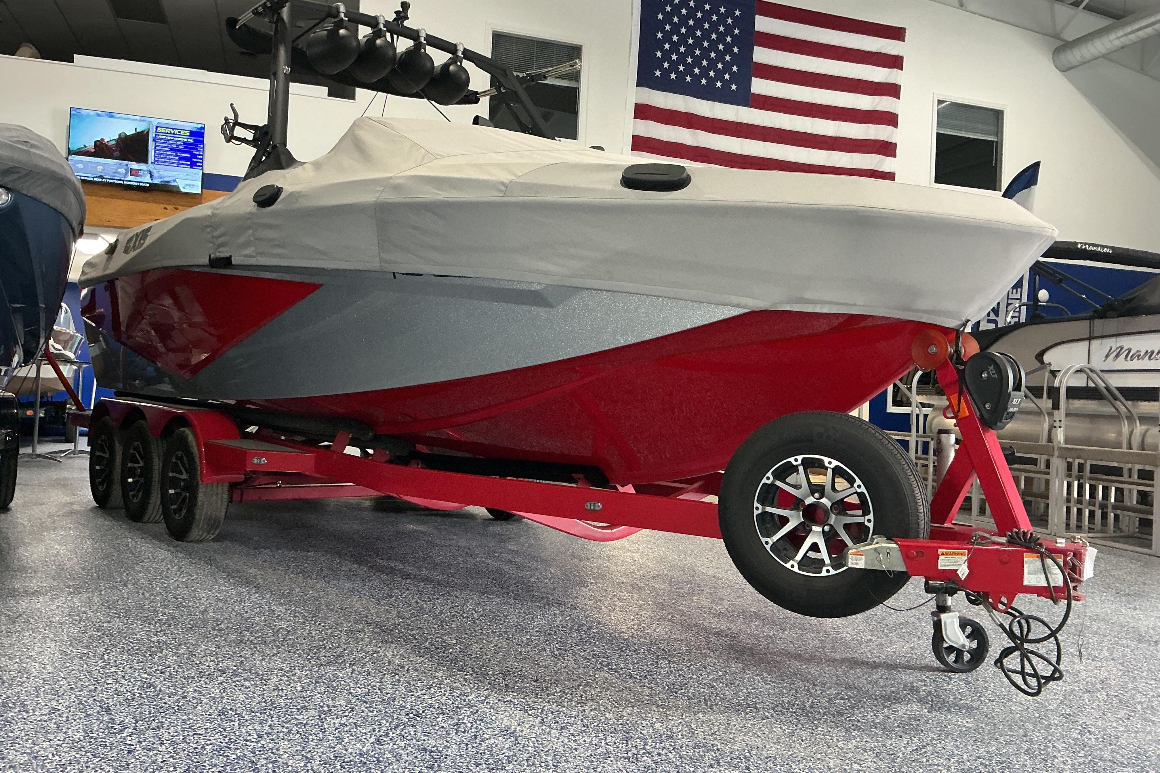 2022 Axis T250 boat on red trailer in showroom with American flag.