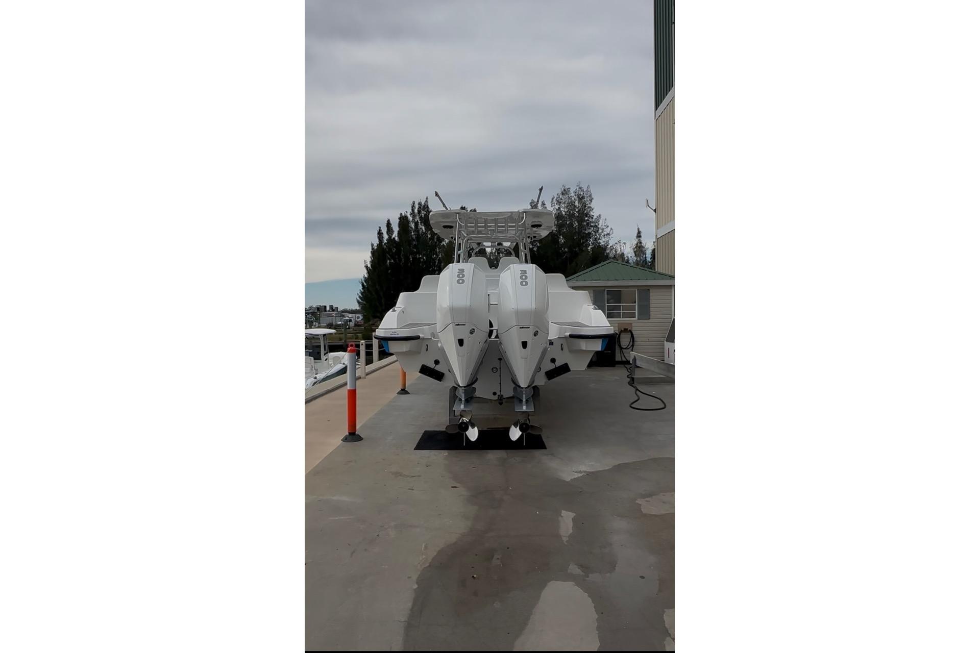 2021 Custom Infusion 34 CC boat with twin engines on a dock.