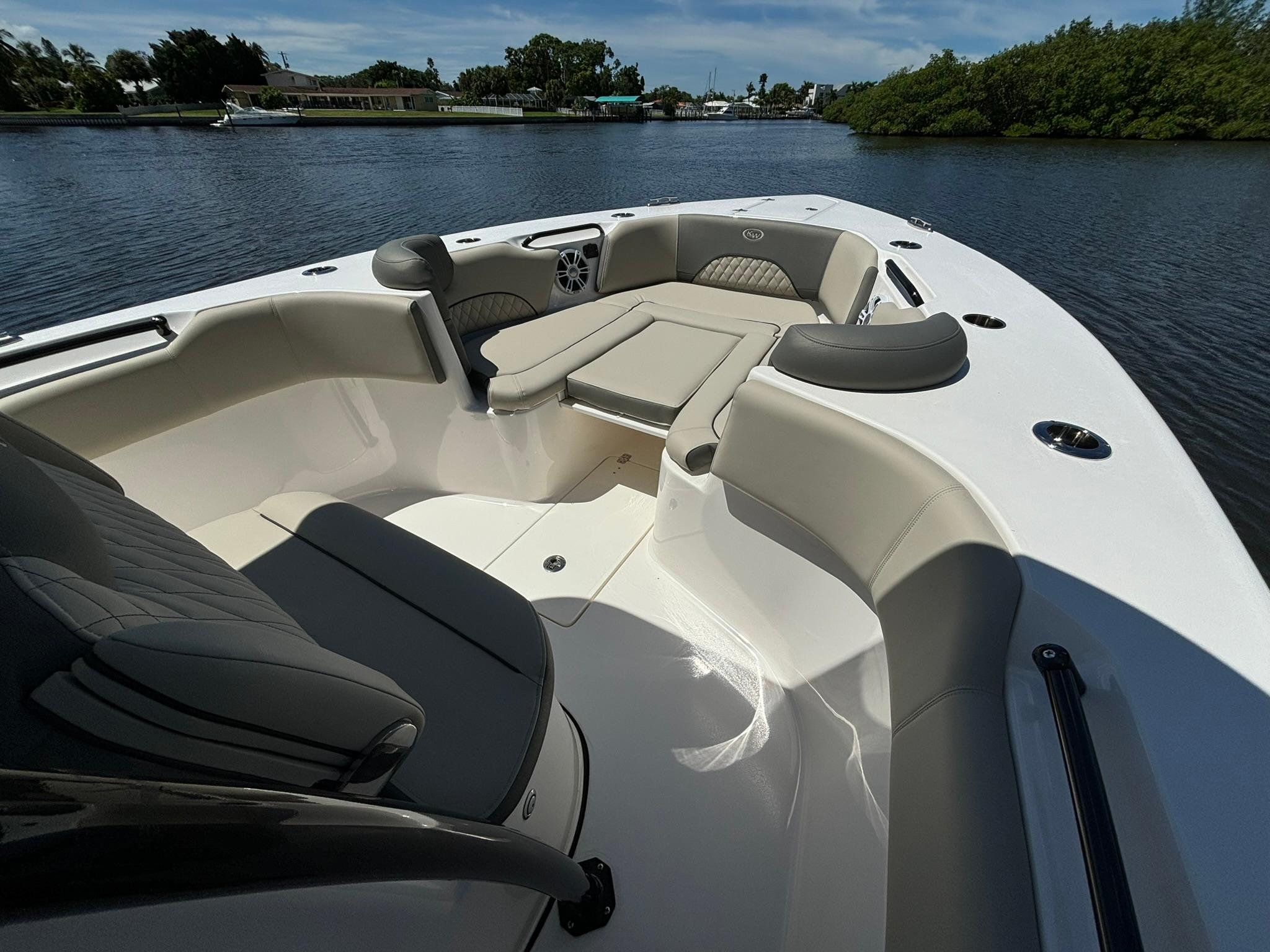 2025 Key West 263 FS boat interior with cushioned seating on a calm waterway.