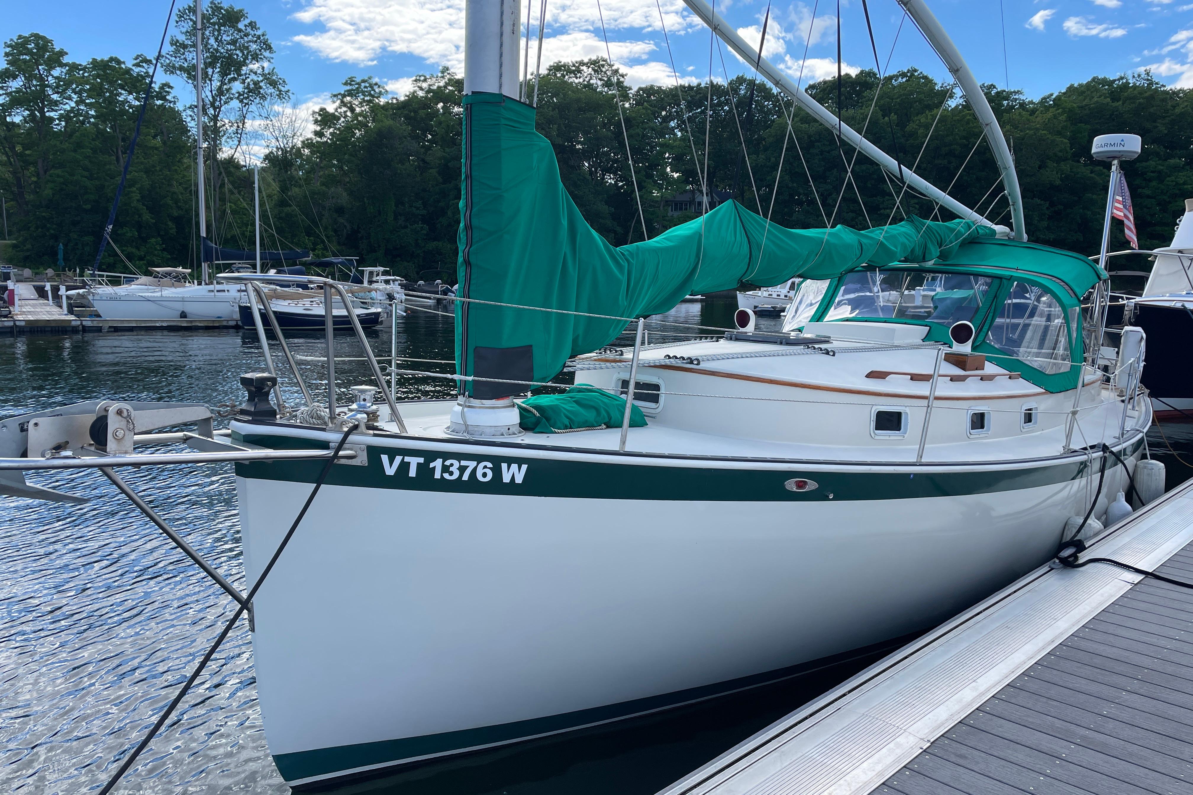 1981 Nonsuch 30 Classic sailboat docked, featuring green sail cover and canopy.