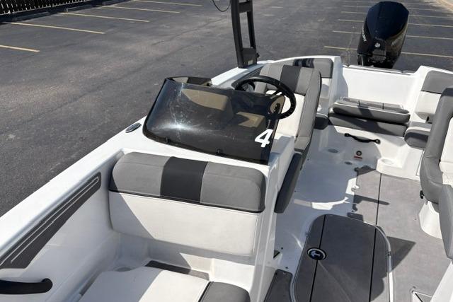 2024 Tahoe T21 boat interior with gray seating and steering wheel, parked in a lot.