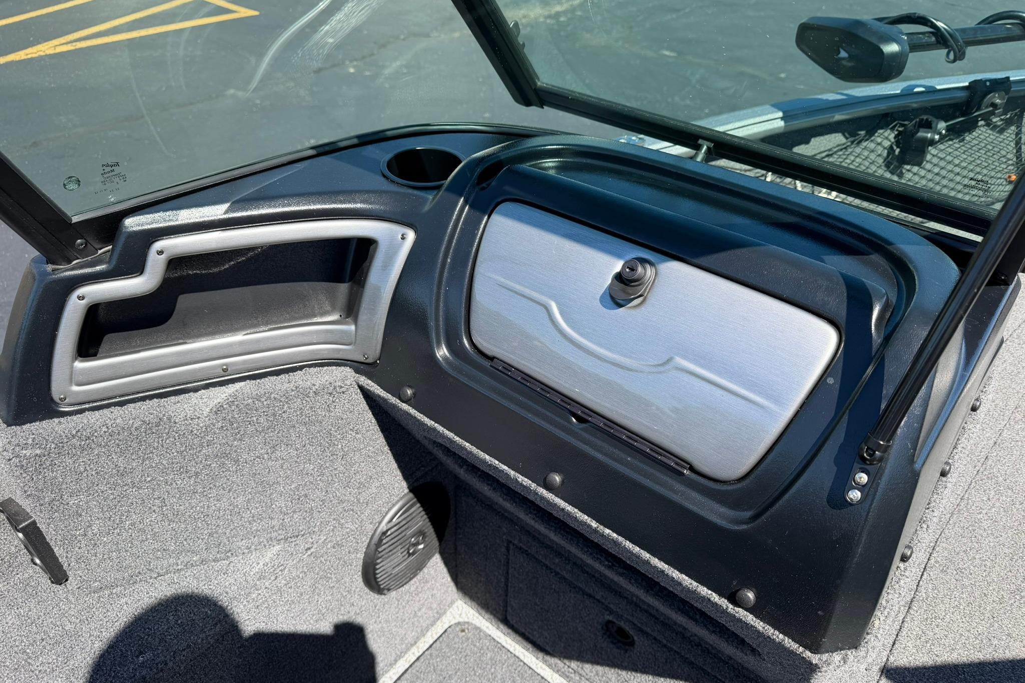 2024 Lund 1875 Impact XS Sport boat dashboard with storage compartment and windshield.
