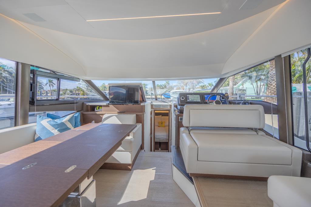 Luxurious interior of 2021 Prestige 520 Flybridge yacht with modern seating and panoramic windows.