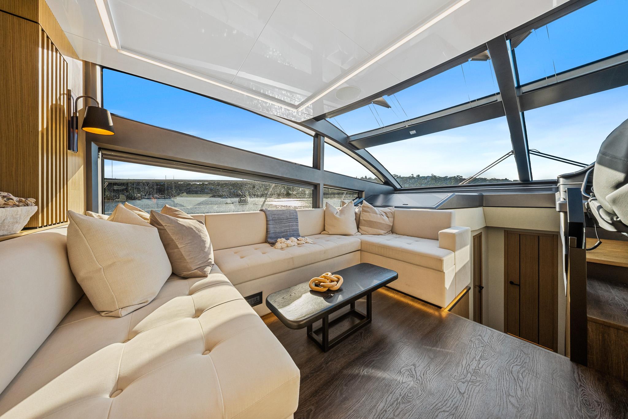 Luxurious interior of 2023 Pearl 62 yacht with modern seating and panoramic windows.