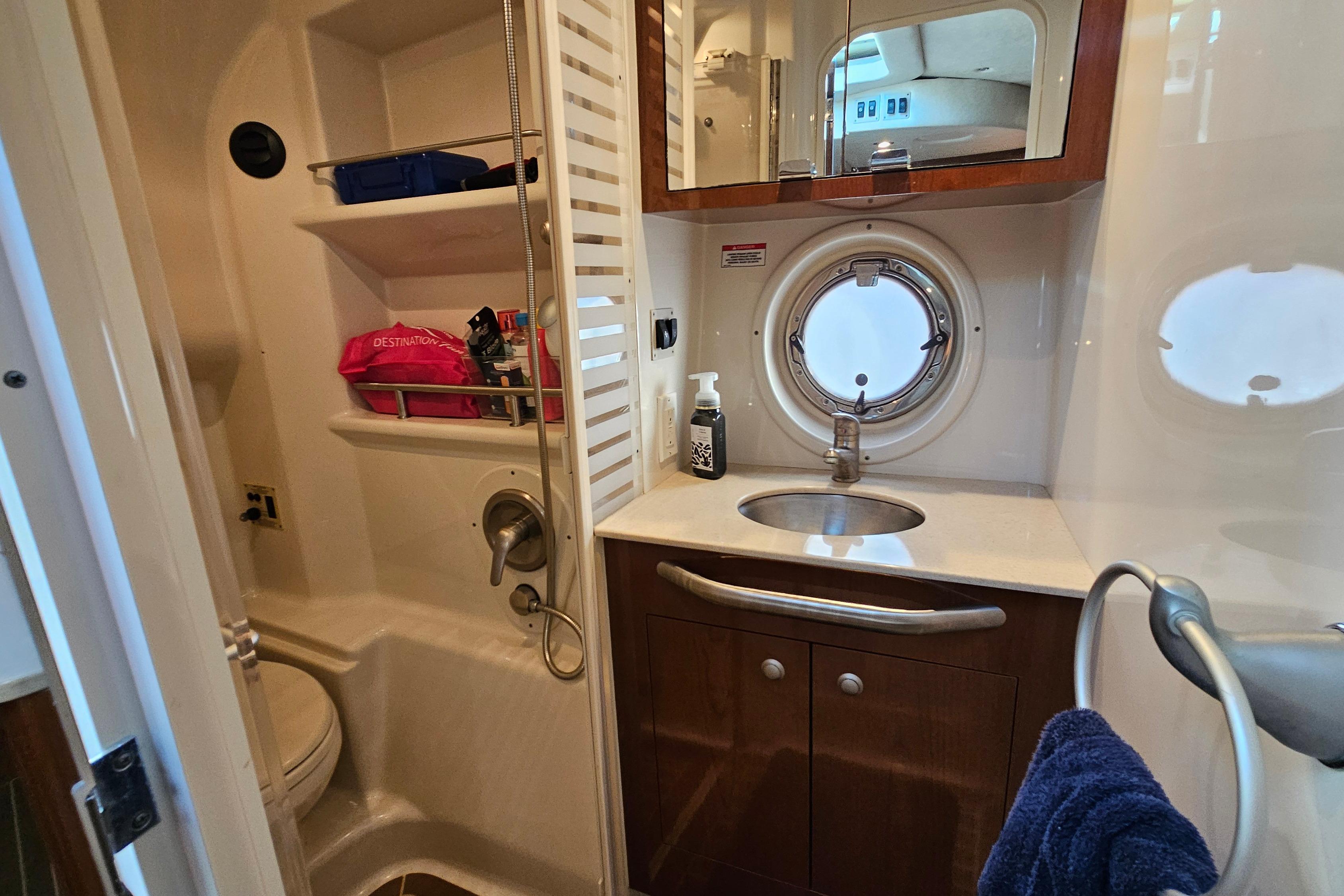 Luxurious 2008 Sea Ray Sundancer 350 yacht bathroom with sink, shower, and porthole window.