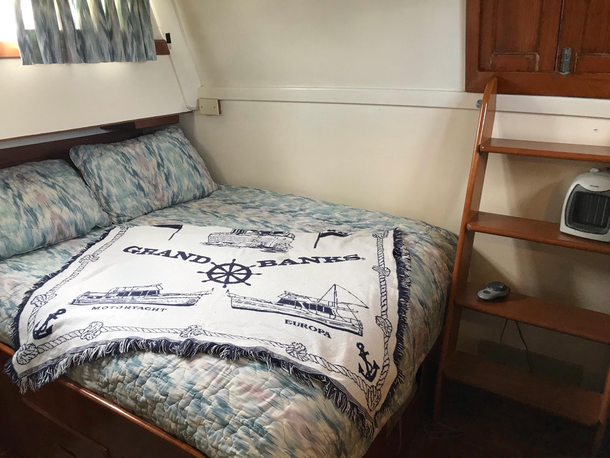 Cozy cabin interior of 1969 Grand Banks 42 Classic with nautical-themed bedding.