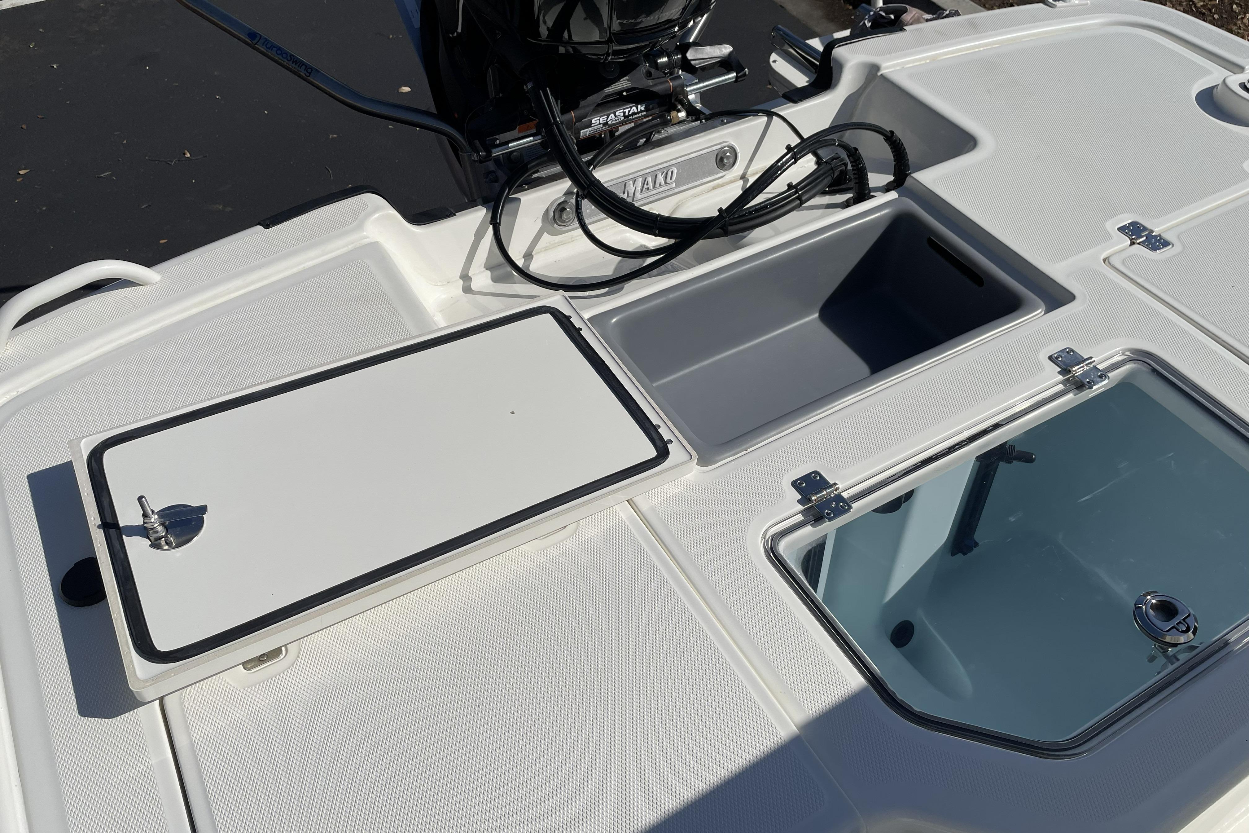 2026 Mako Pro Skiff 19 CC boat deck with storage compartments and motor.