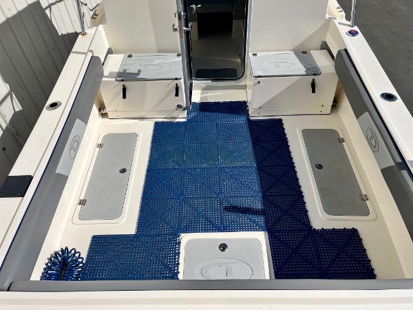 2023 Defiance Admiral 220 EX boat interior with blue mat and storage compartments.