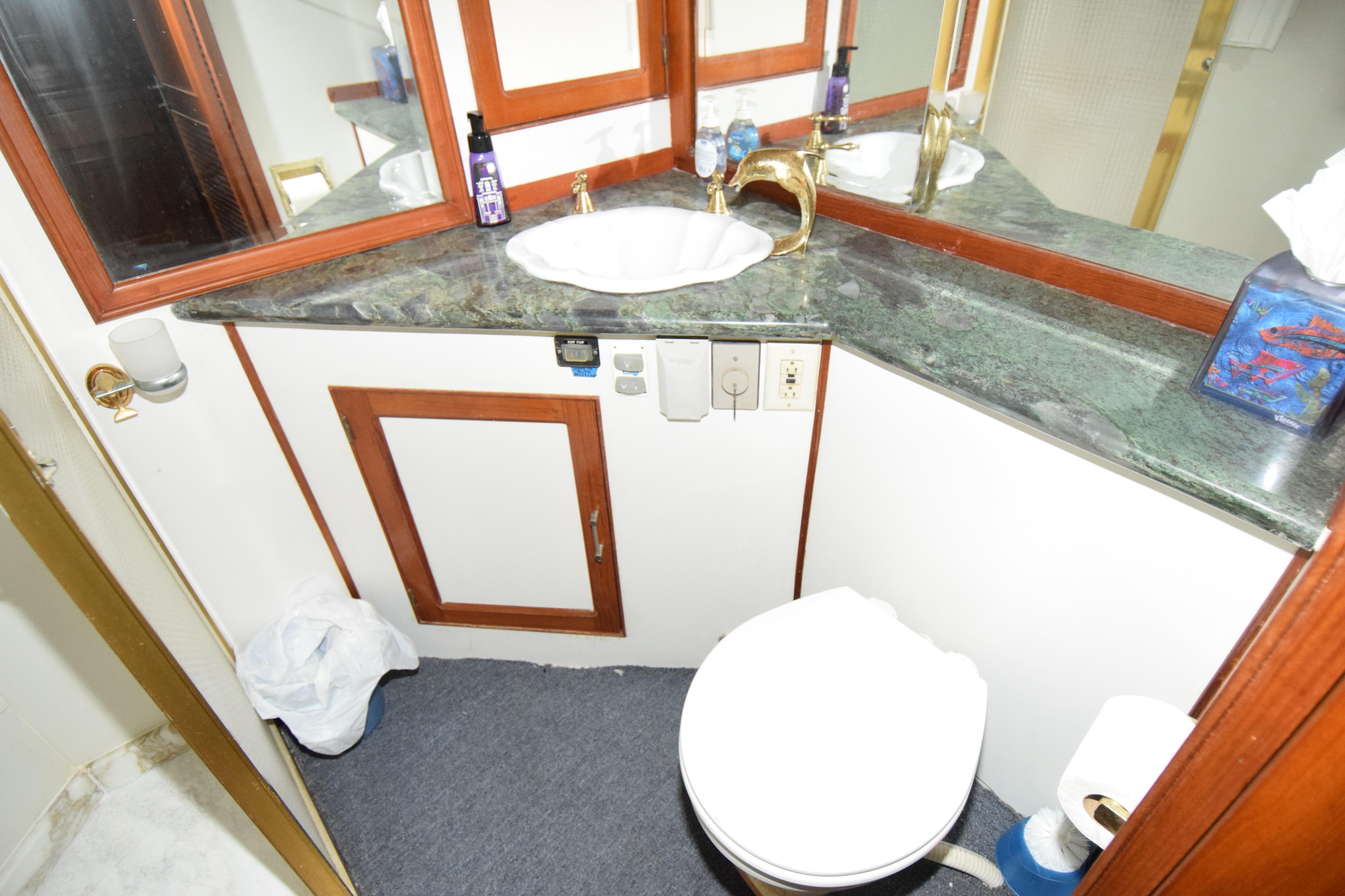 Bathroom interior of 1988 Sea Ranger 51 Motor Yacht with sink and toilet.