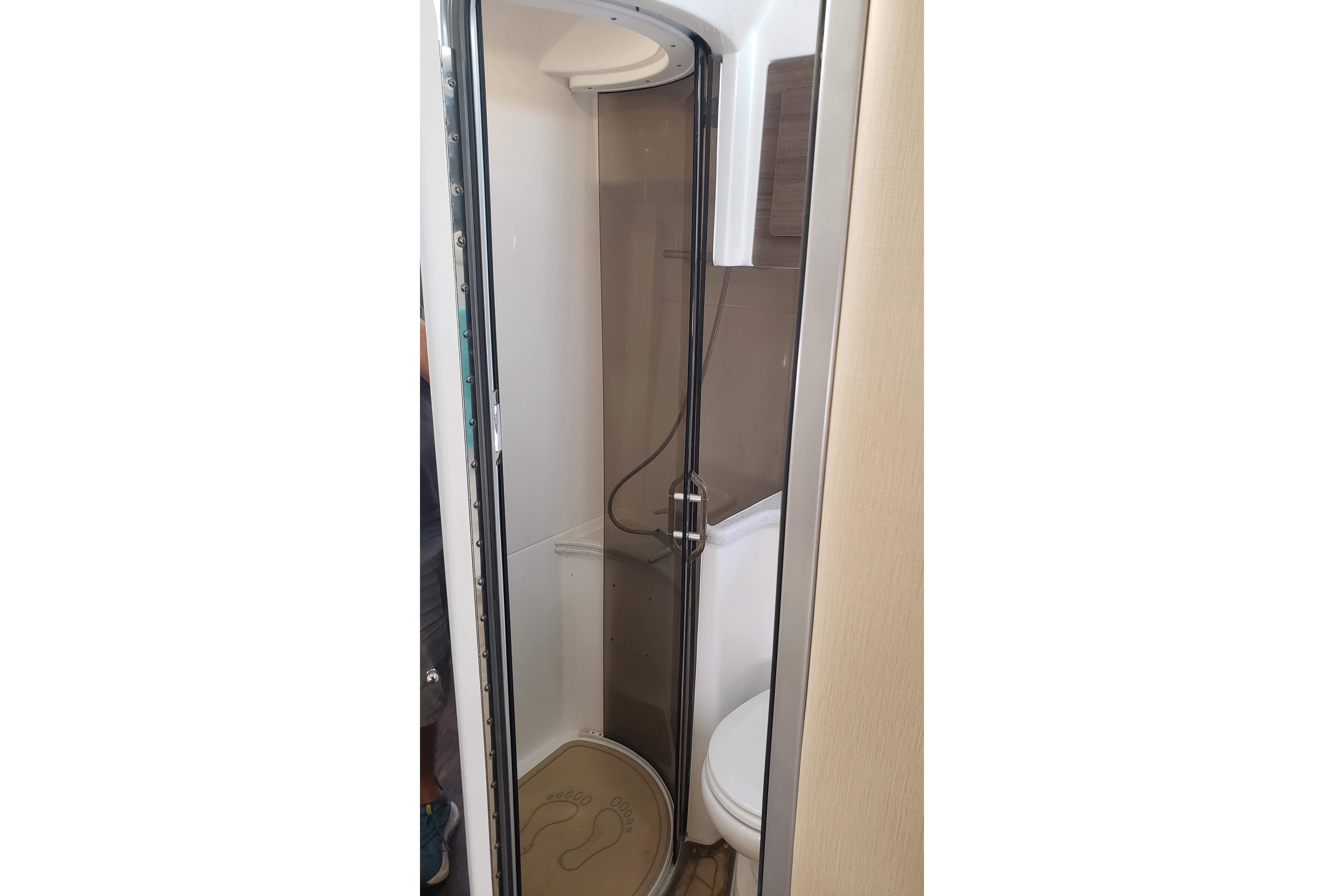 2019 Rinker EX 370 bathroom with shower and toilet, featuring modern design and compact space.