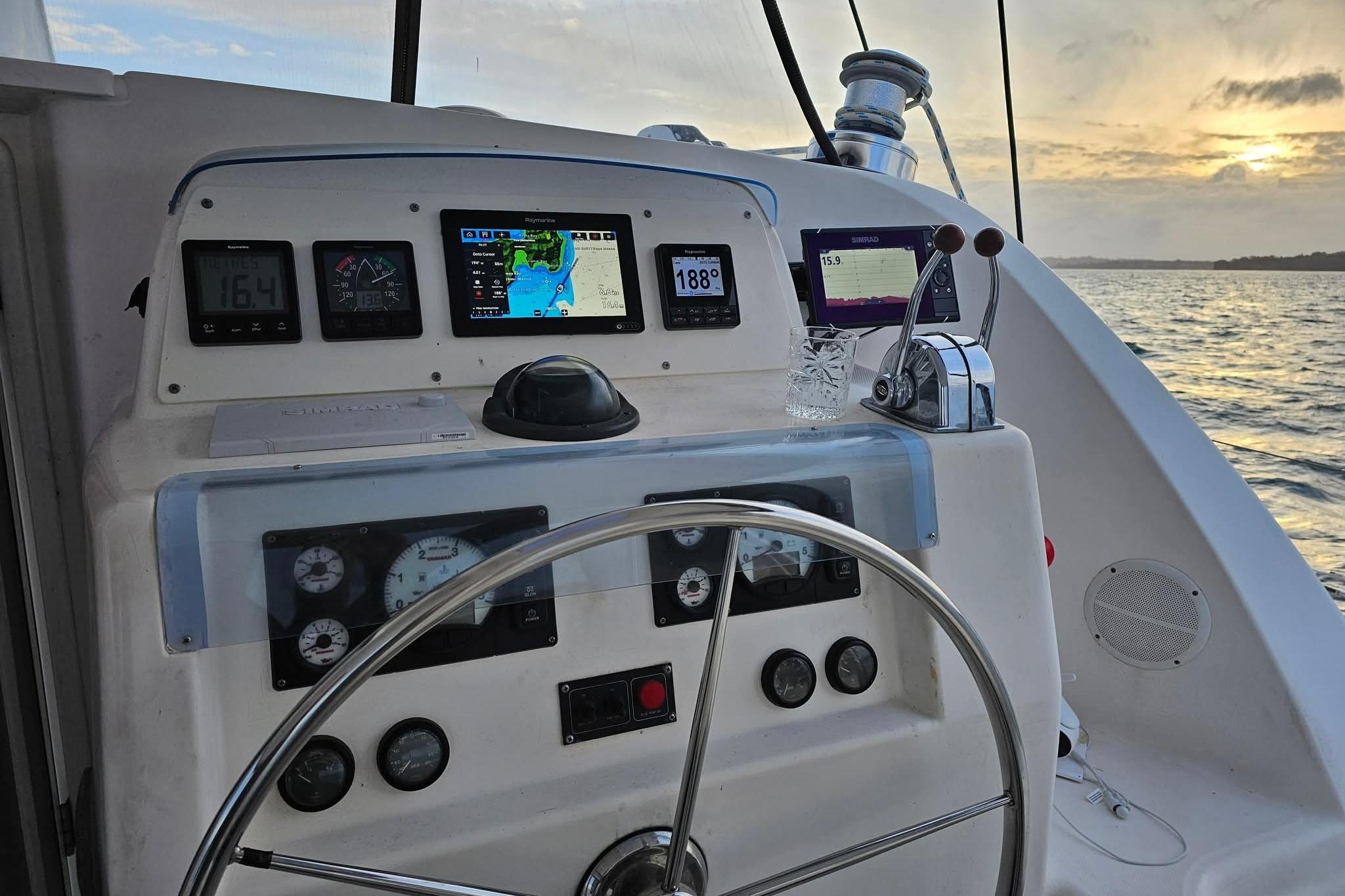 Steering console of a 2007 Leopard 43 yacht at sunset, featuring navigation instruments.