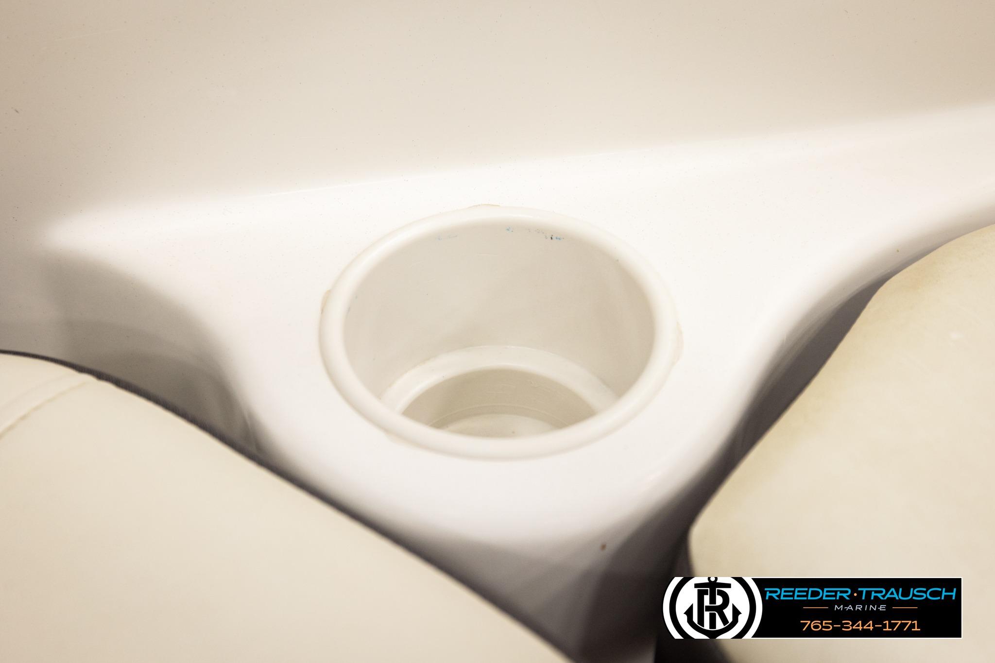 Cup holder in a 2016 Tahoe 450 TS boat interior, featuring beige seating.